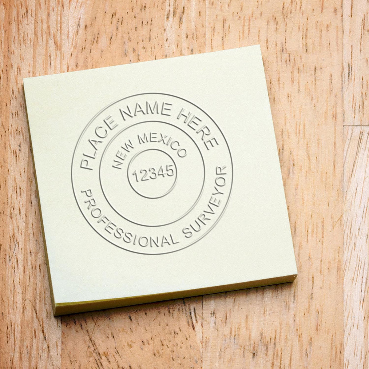 An in use photo of the Gift New Mexico Land Surveyor Seal showing a sample imprint on a cardstock