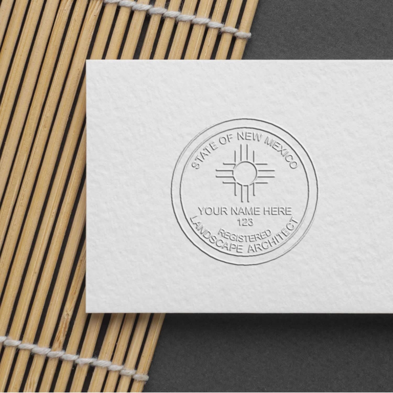 An in use photo of the Gift New Mexico Landscape Architect Seal showing a sample imprint on a cardstock