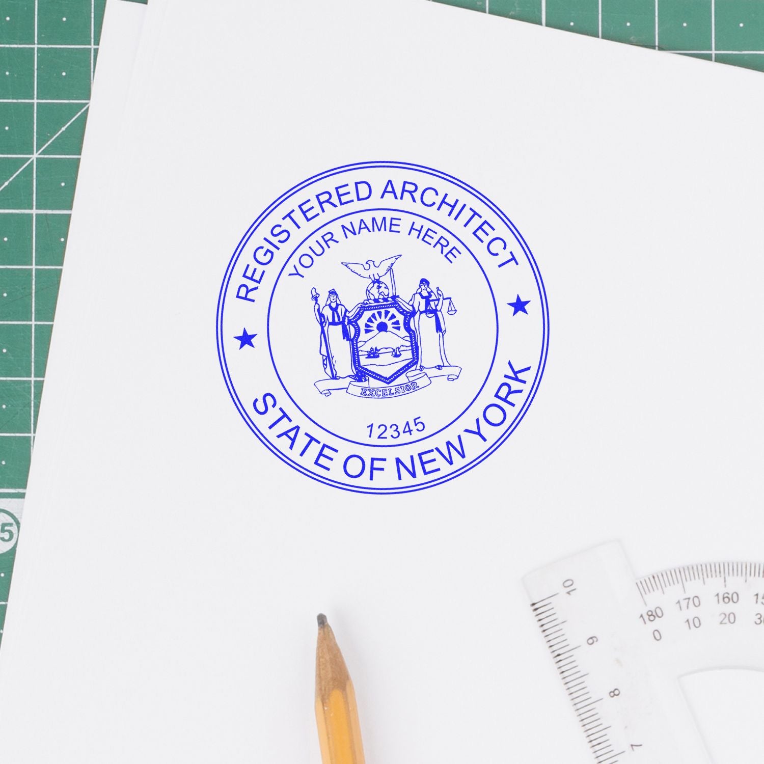 Self Inking New York Architect Stamp imprint on white paper, surrounded by a pencil, ruler, and cutting mat.