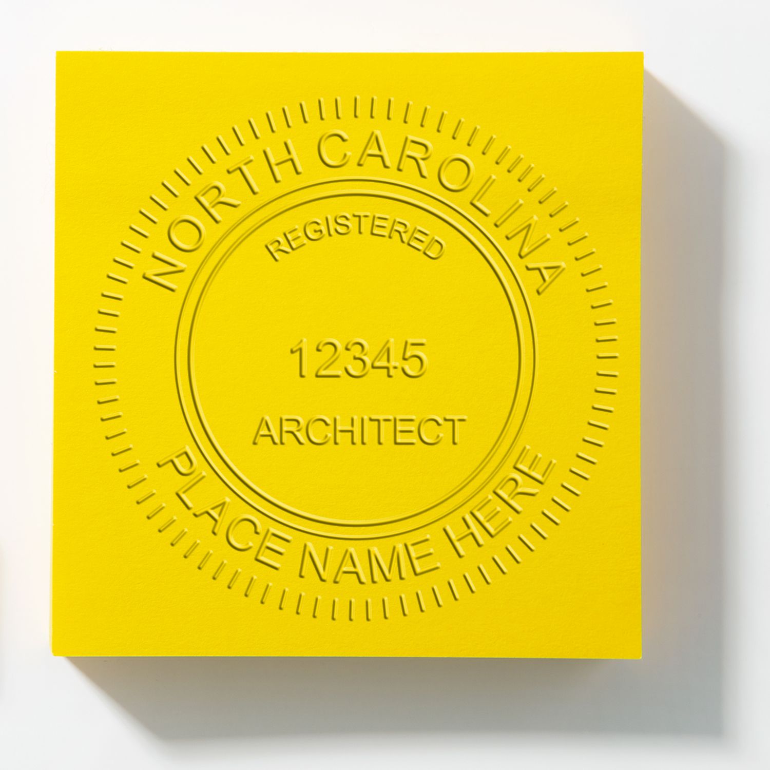 This paper is stamped with a sample imprint of the Handheld North Carolina Architect Seal Embosser, signifying its quality and reliability.
