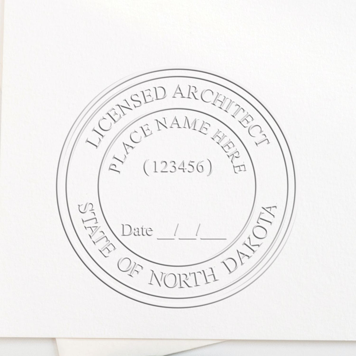 A lifestyle photo showing a stamped image of the Handheld North Dakota Architect Seal Embosser on a piece of paper
