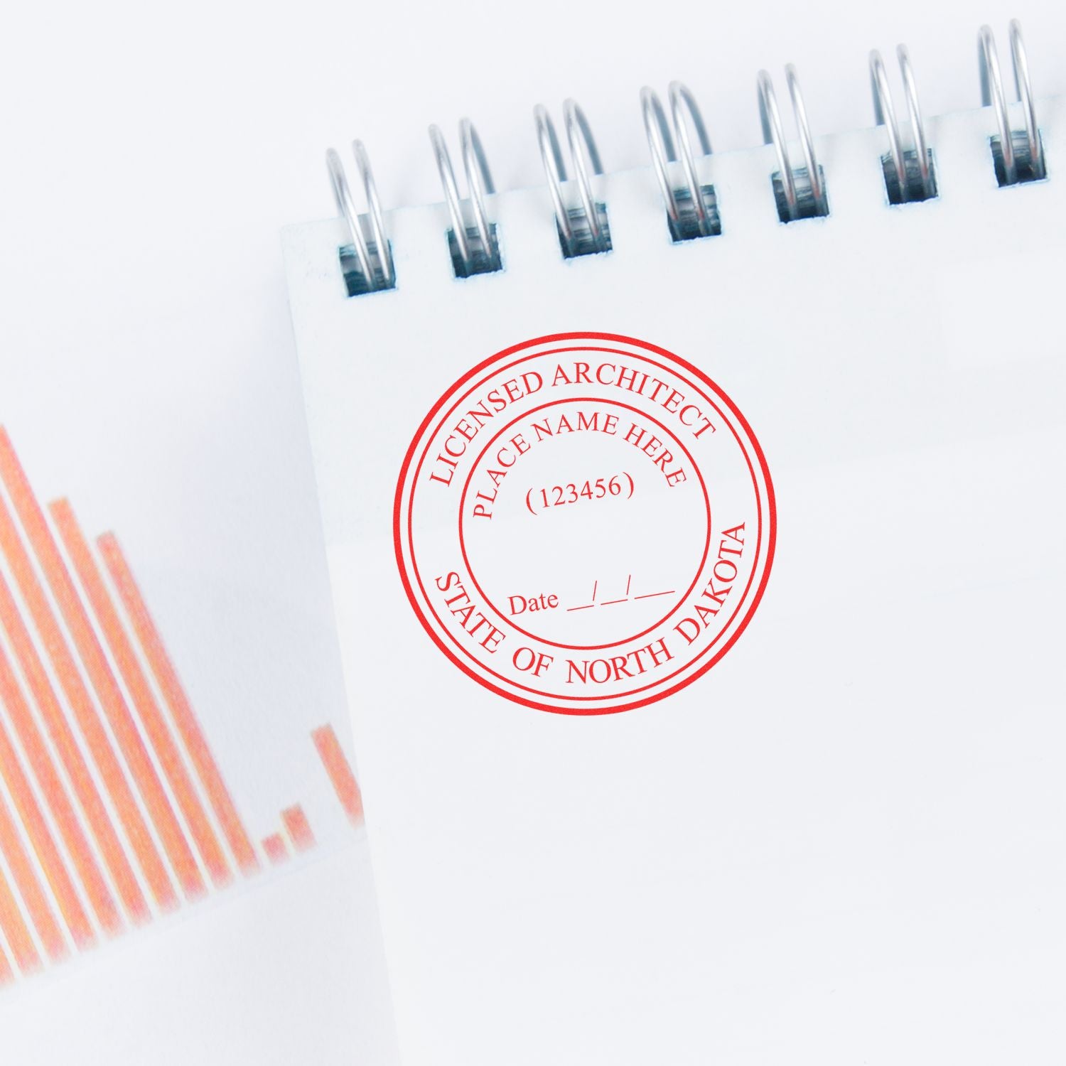 North Dakota Architect Seal Stamp in red ink on a white notepad with a spiral binding, next to an orange bar graph.