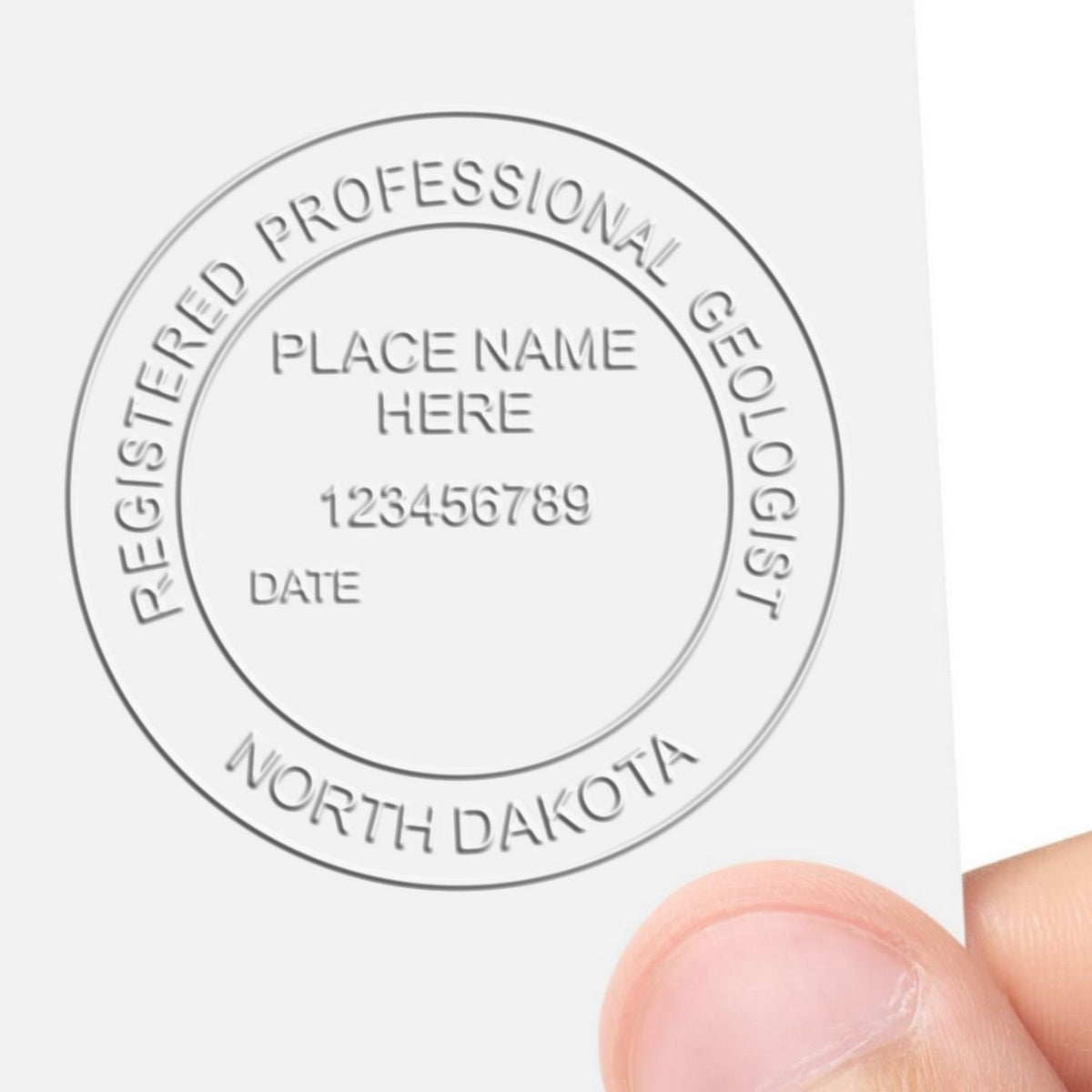 A lifestyle photo showing a stamped image of the Heavy Duty Cast Iron North Dakota Geologist Seal Embosser on a piece of paper