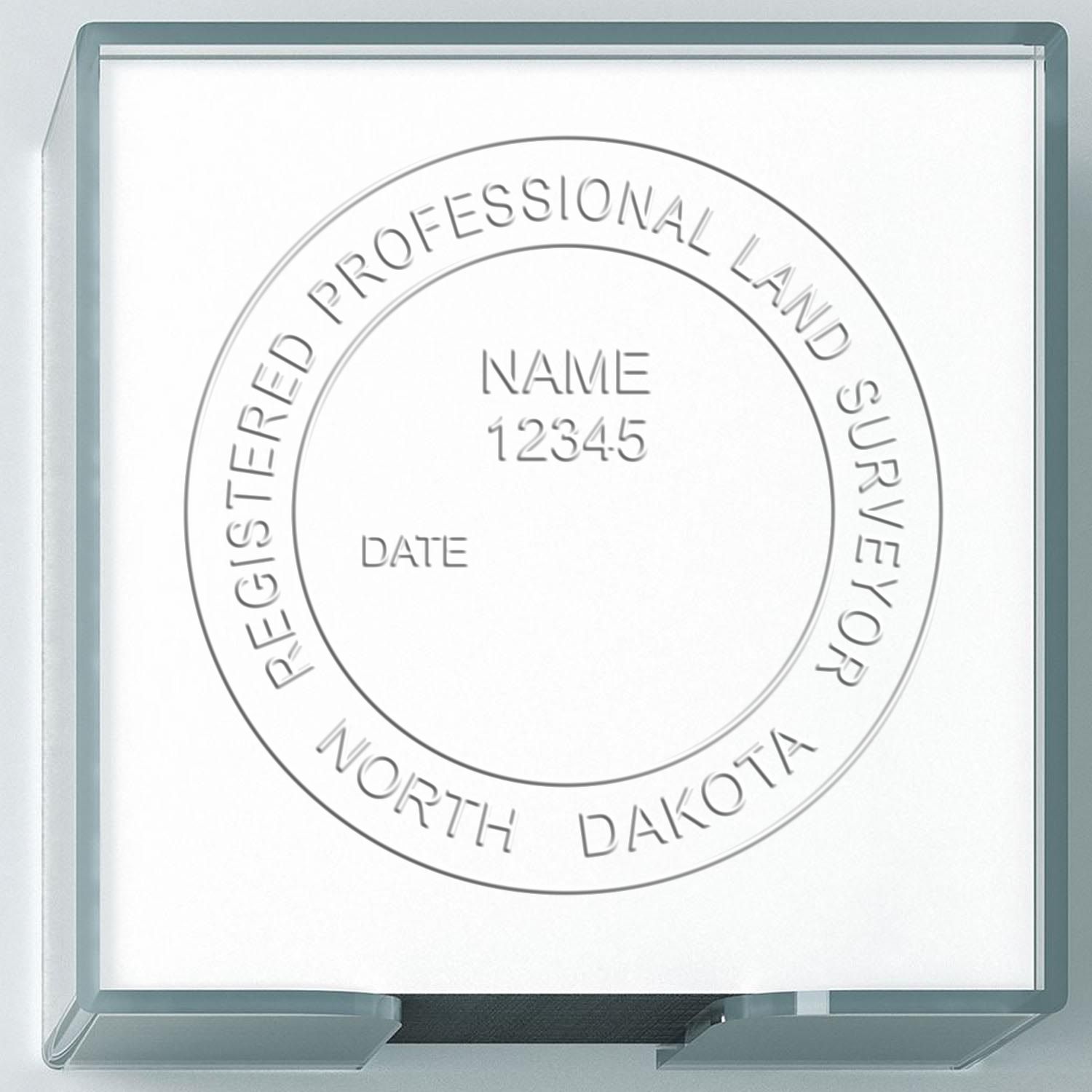 A lifestyle photo showing a stamped image of the Handheld North Dakota Land Surveyor Seal on a piece of paper