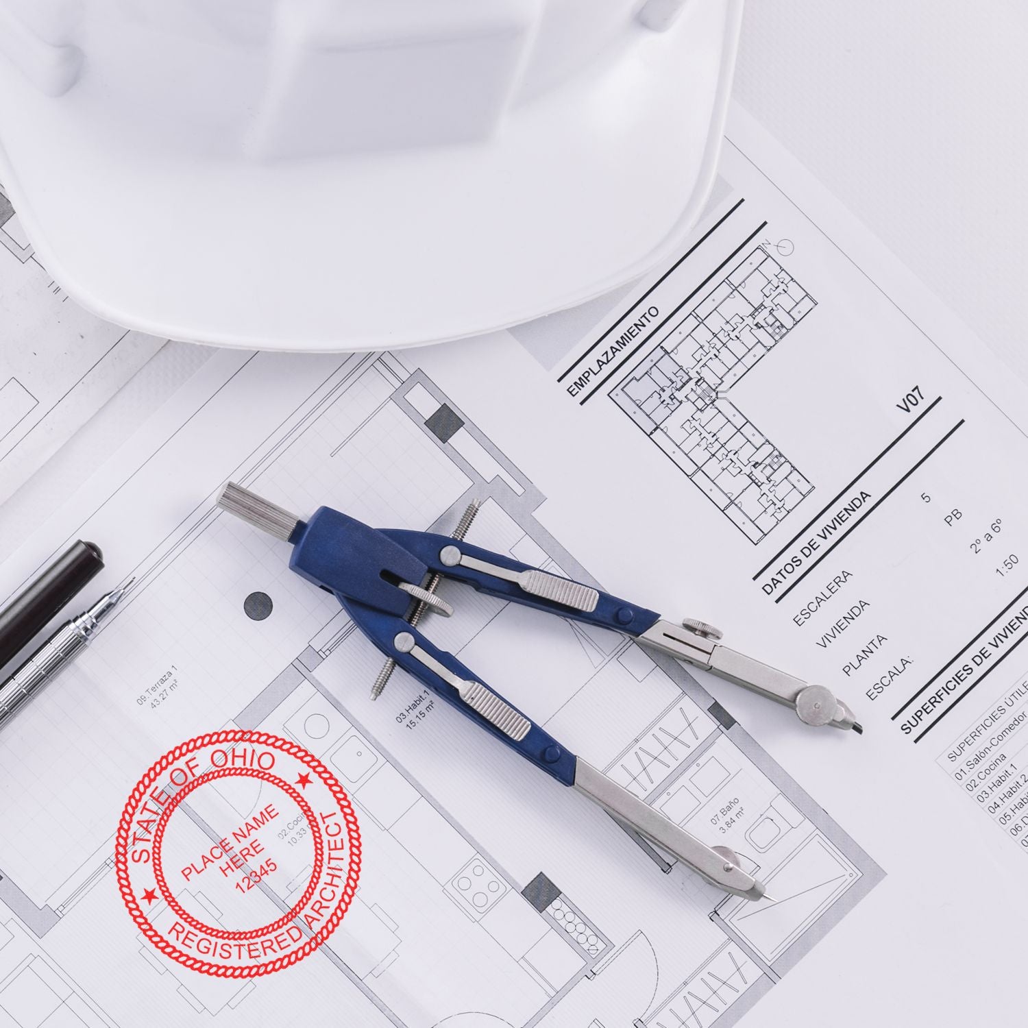 Self Inking Ohio Architect Stamp on architectural plans with a compass, pen, and hard hat in the background.