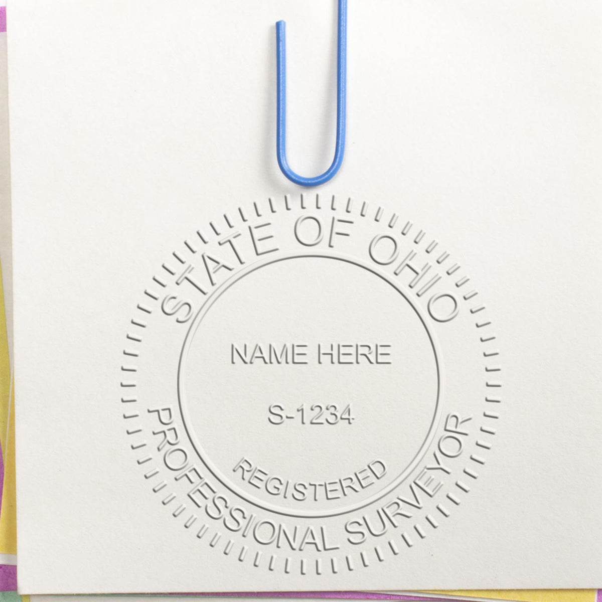 An in use photo of the Hybrid Ohio Land Surveyor Seal showing a sample imprint on a cardstock