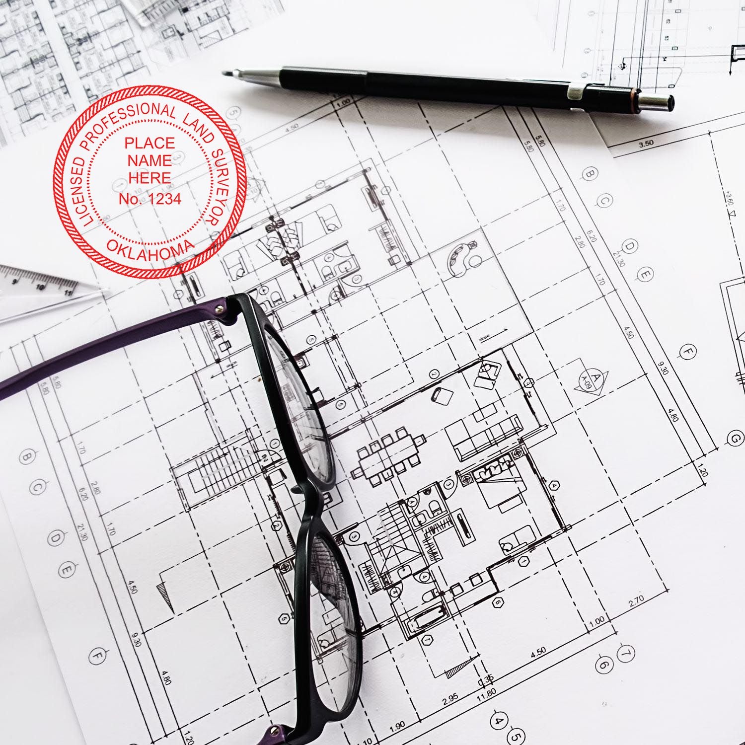 Premium MaxLight Pre-Inked Oklahoma Surveyors Stamp on architectural plans with glasses and pen nearby.