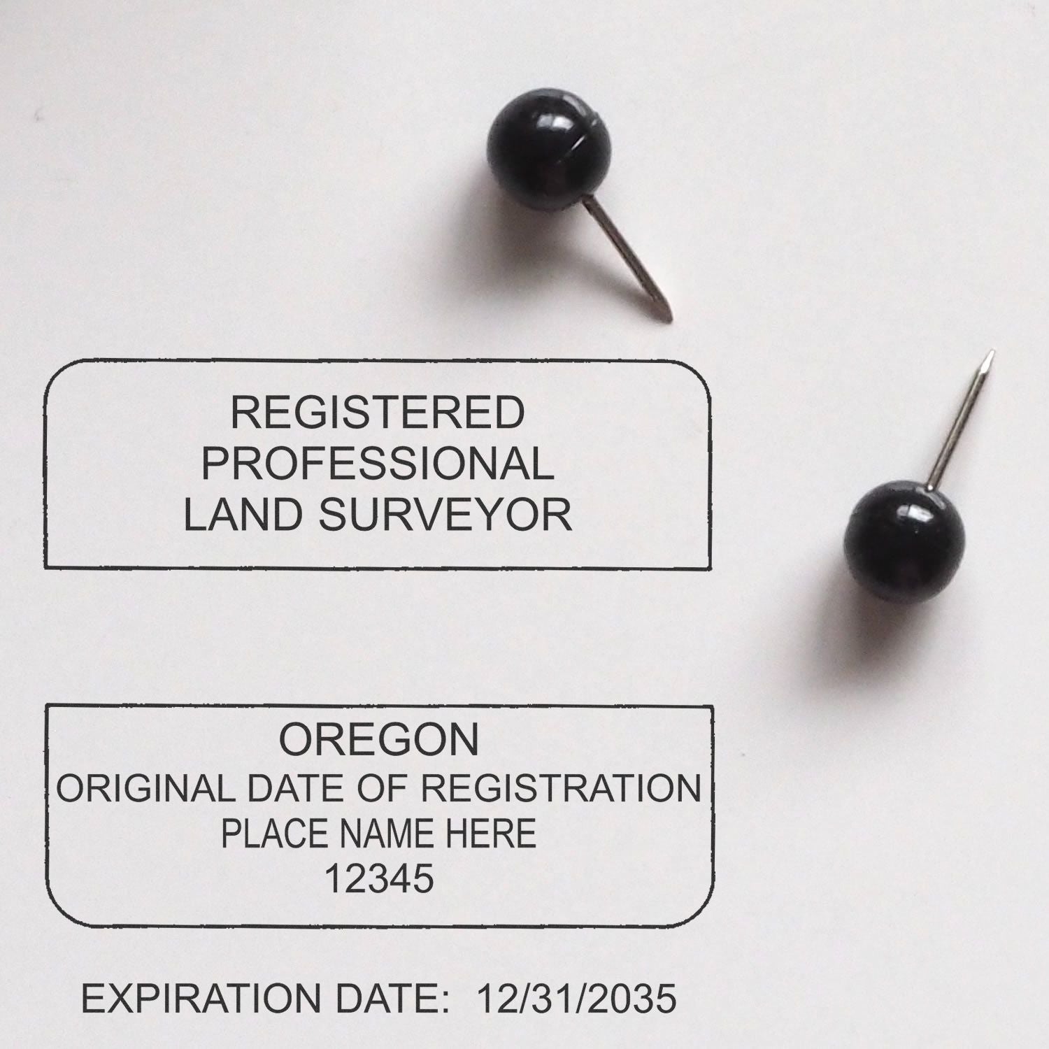 Premium MaxLight Pre-Inked Oregon Surveyors Stamp used on a document with black push pins, showing registration details and expiration date.