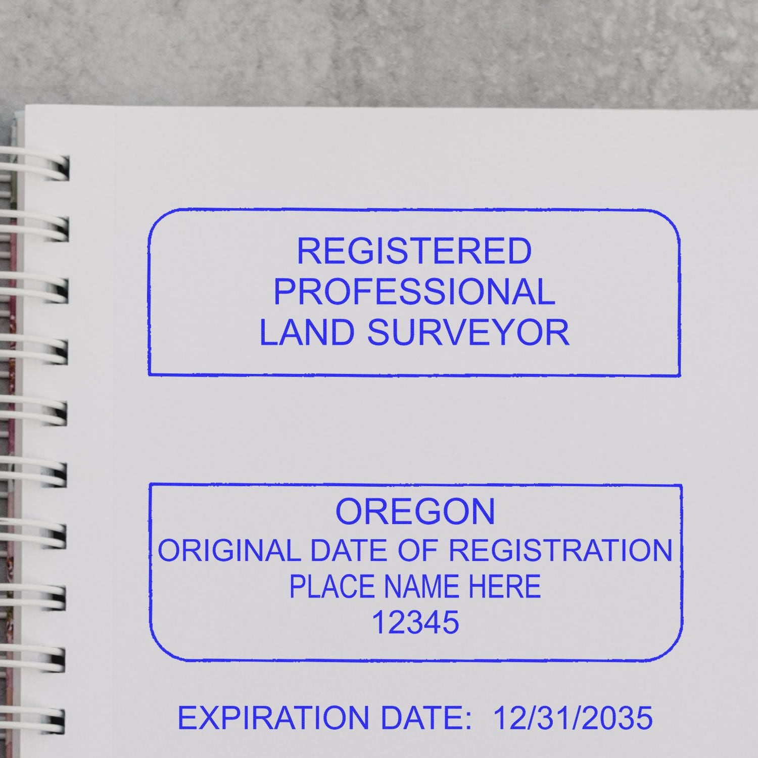 Premium MaxLight Pre-Inked Oregon Surveyors Stamp on a notebook, showing Registered Professional Land Surveyor and registration details.