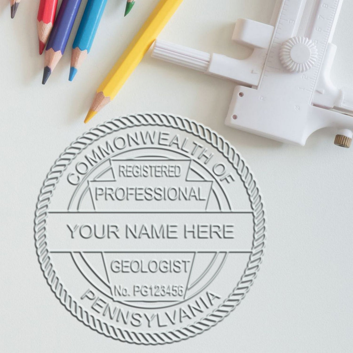 A lifestyle photo showing a stamped image of the Heavy Duty Cast Iron Pennsylvania Geologist Seal Embosser on a piece of paper
