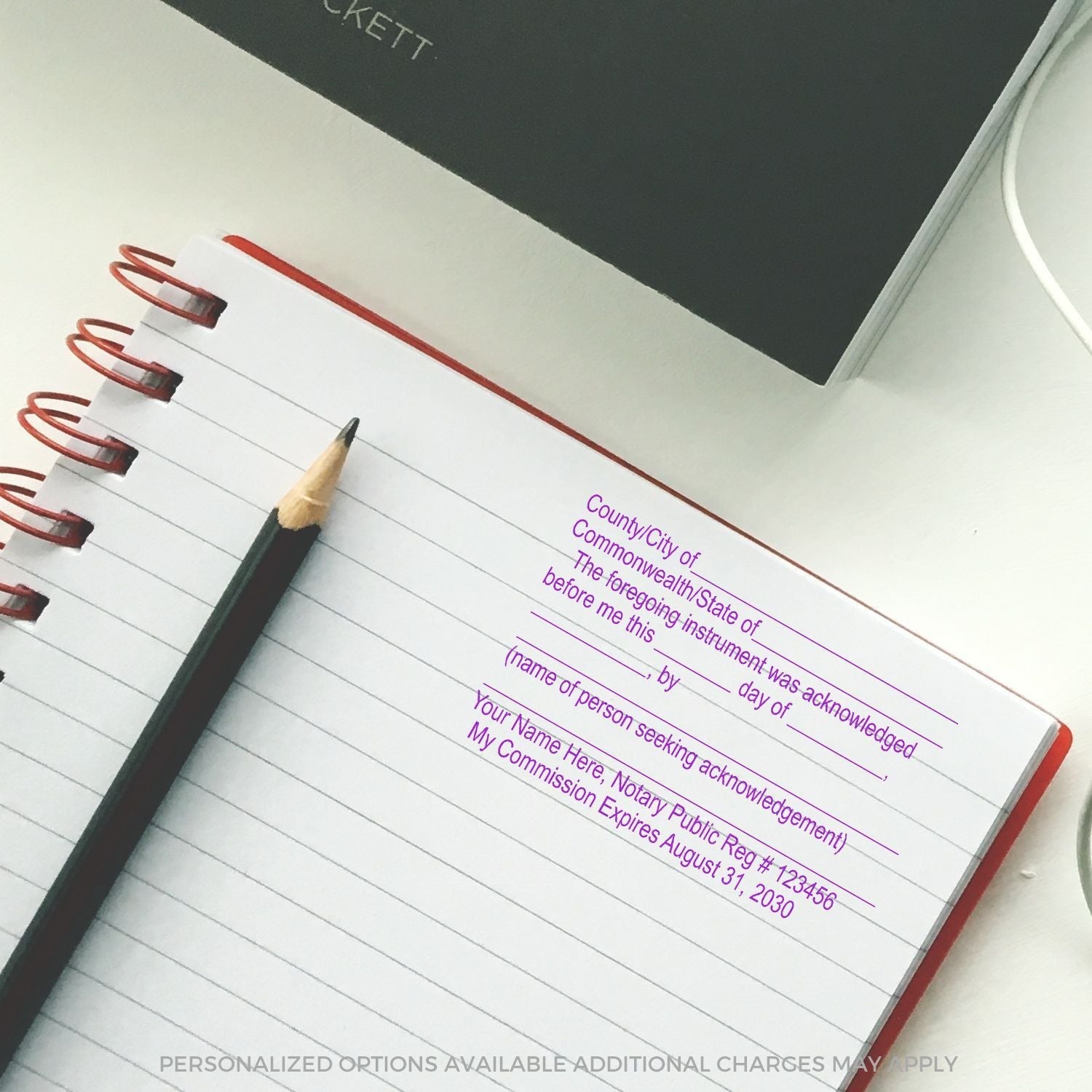 Notary Acknowledgment Stamp in use on a lined notebook, showing a personalized acknowledgment template with purple ink.