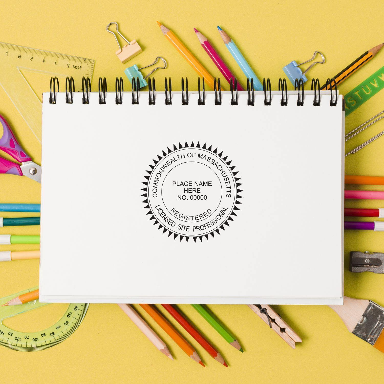 A Professional Slim Pre-Inked Rubber Stamp of Seal imprint on a white notebook, surrounded by colorful stationery on a yellow background.