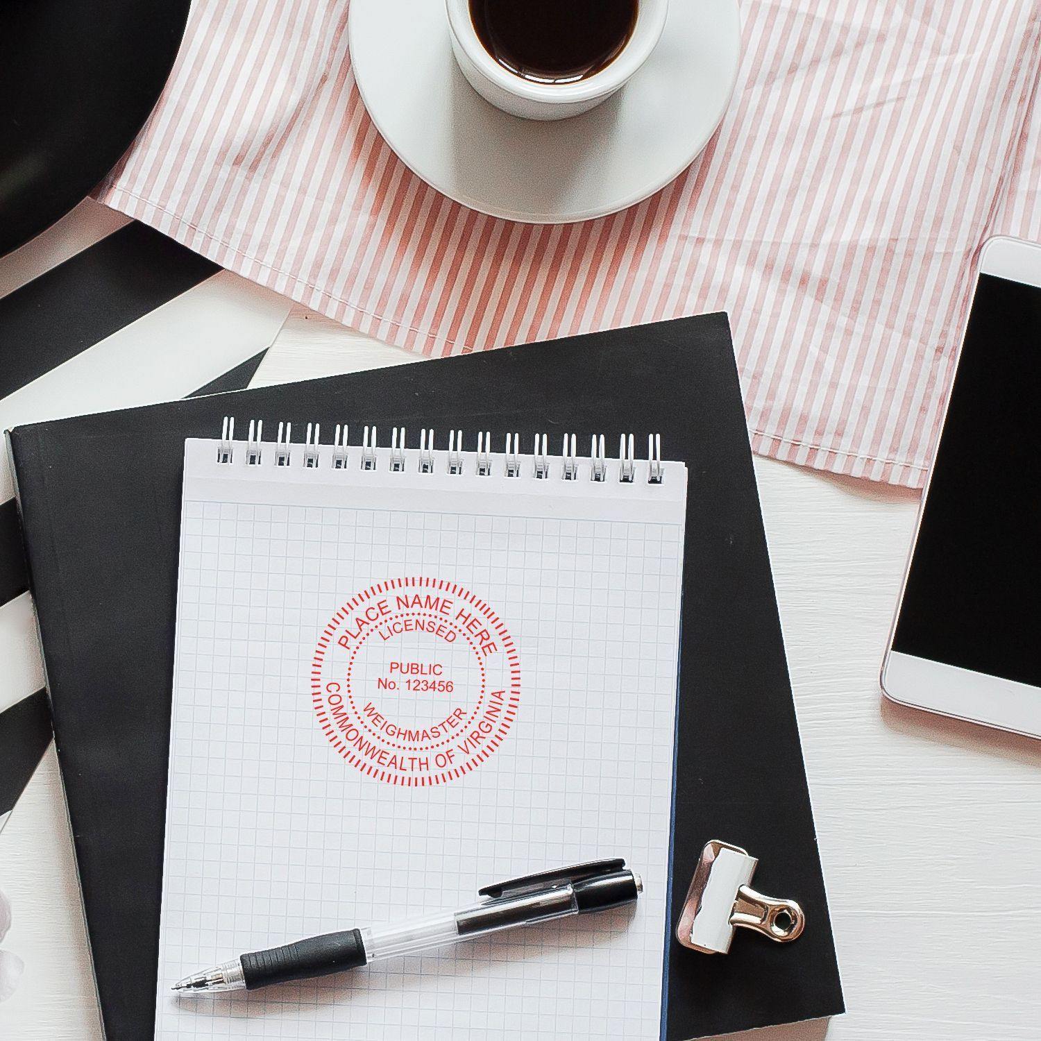 Public Weighmaster Regular Rubber Stamp of Seal on a notepad, with a pen, coffee cup, and smartphone on a white desk.