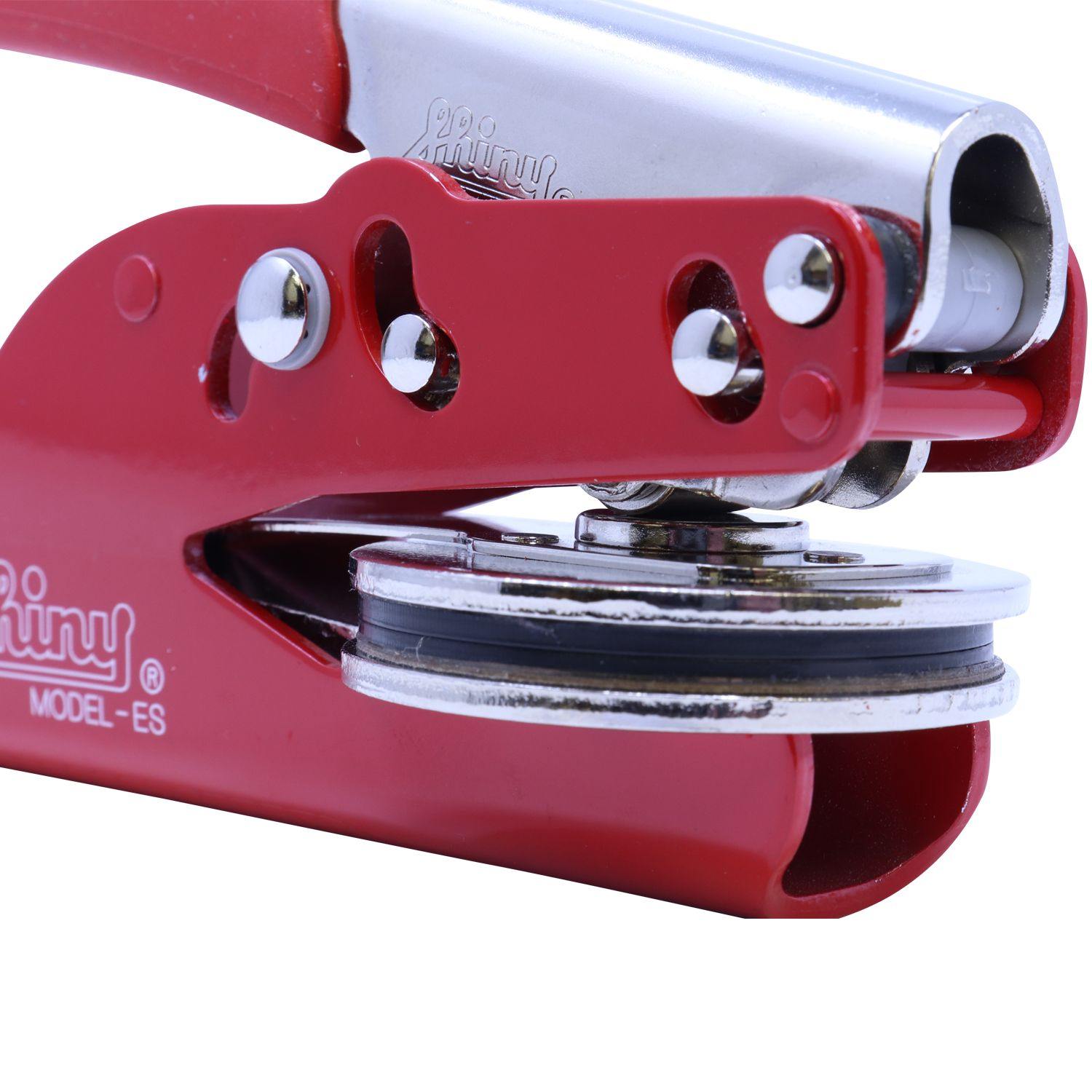 Close-up of the Geologist Red Soft Seal Embosser, showing its red handle and metal embossing mechanism with detailed components.