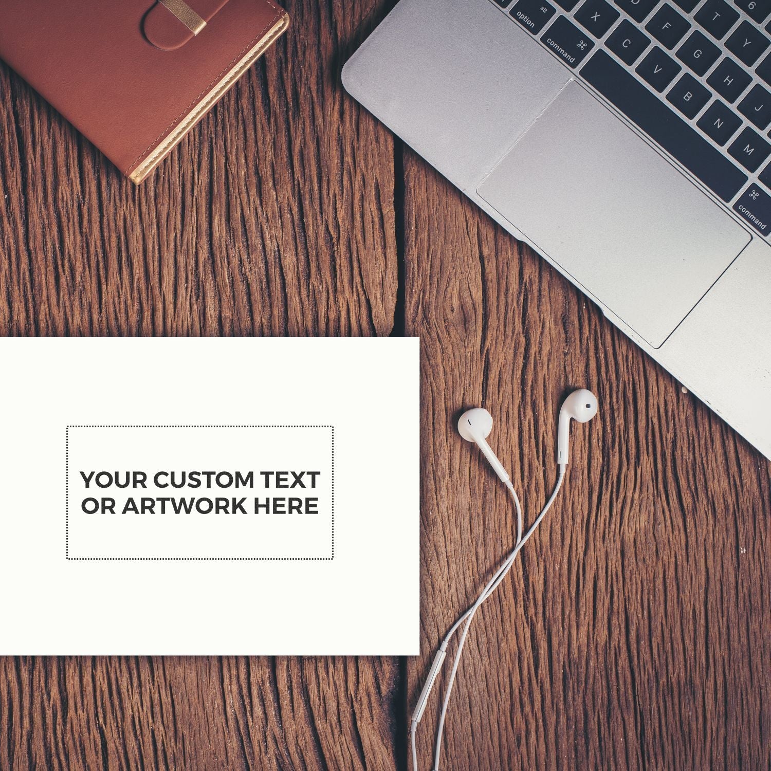 Custom Rubber Stamp Size 2 x 4 on a wooden desk with a laptop, earphones, and a notebook, displaying Your Custom Text or Artwork Here.