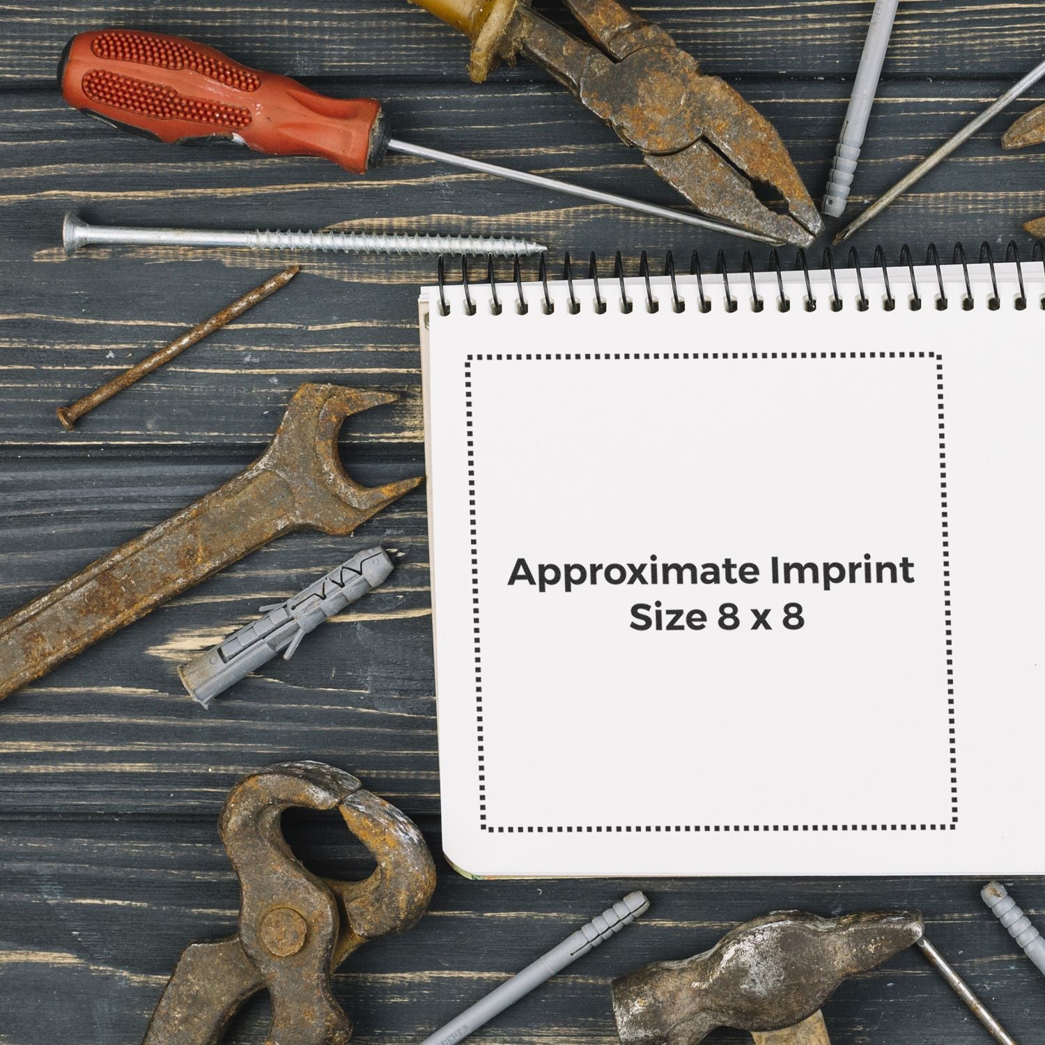 Custom Rubber Stamp Size 8 x 8 shown on a notepad surrounded by various tools on a wooden surface.