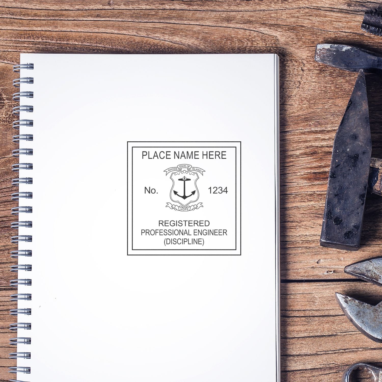 A Professional Engineer Slim Pre-Inked Stamp of Seal is used on a white spiral notebook placed on a wooden desk with various tools nearby. The stamp imprint includes space for a name, number, and discipline.