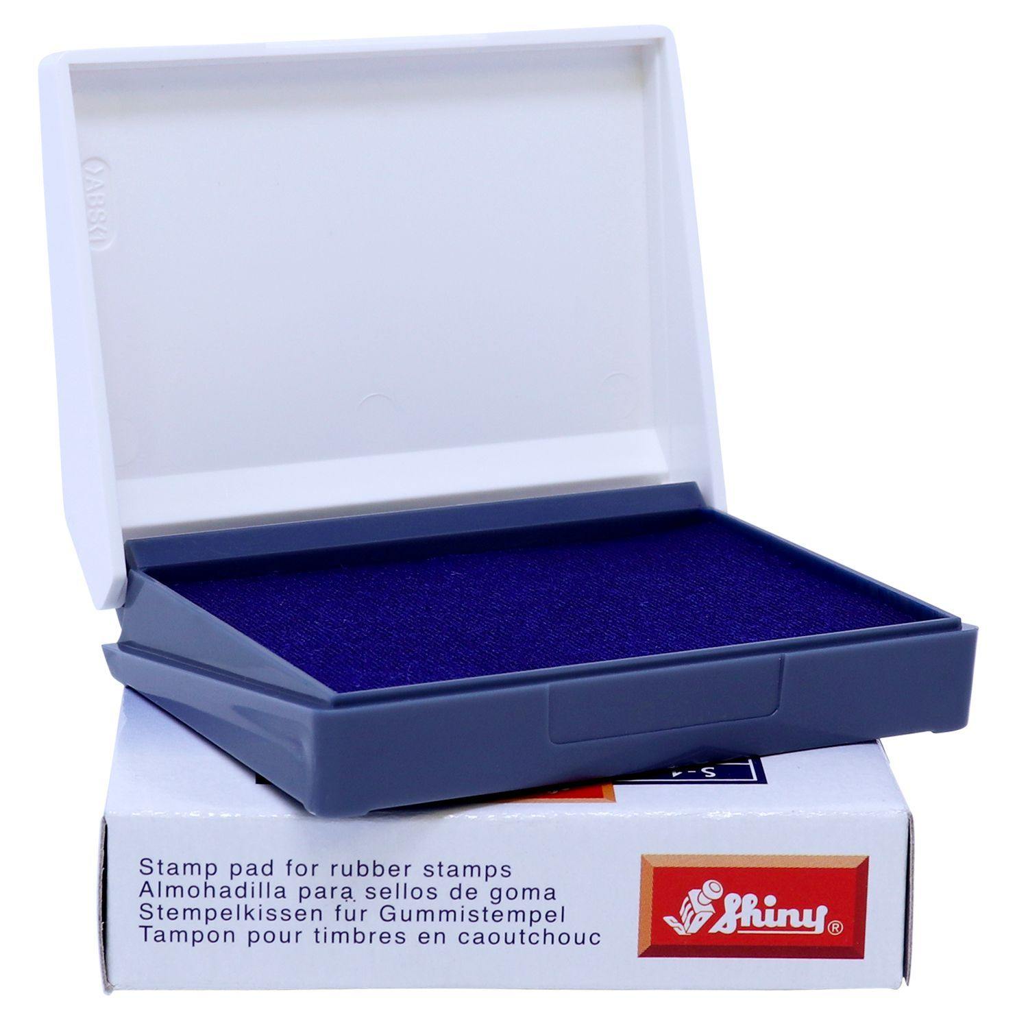 Rubber Stamp Ink Pad 00 Size 1-1/2 x 2-3/4 in blue, open with a white lid, placed on a box with multilingual text and a red logo.