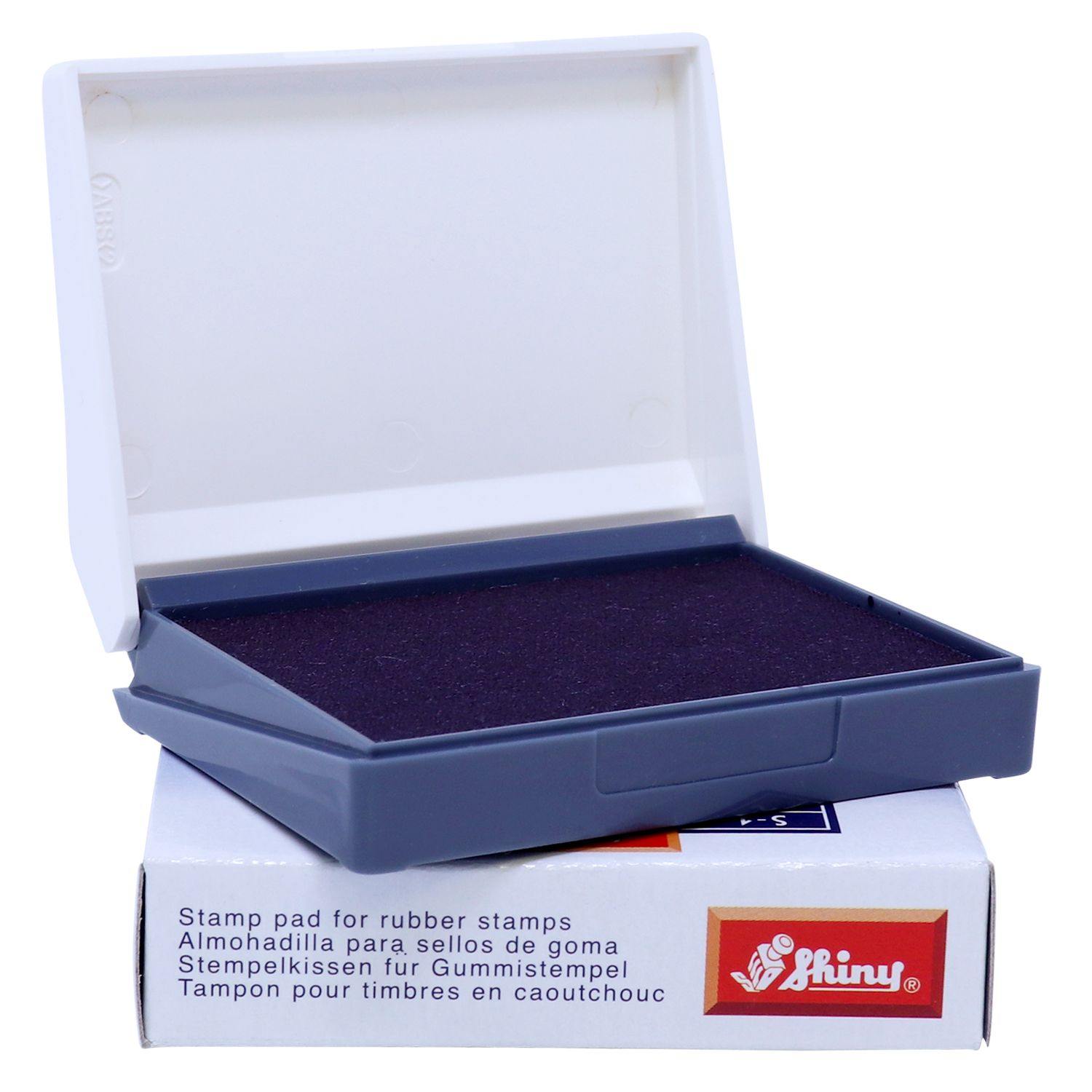 Rubber Stamp Ink Pad 00 Size 1-1/2 x 2-3/4 in purple, open with a white lid, placed on a white box with product details and logo.