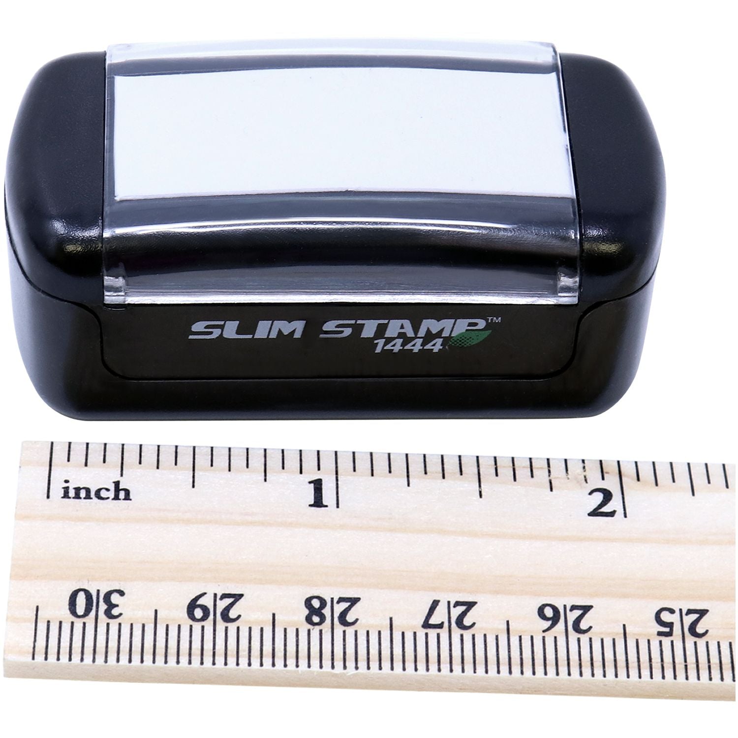 Slim Pre-Inked Entered with Date Box Stamp next to a wooden ruler showing measurements in inches and centimeters.