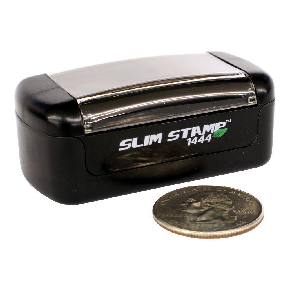 Slim Pre-Inked Not Approved For Construction Stamp, black and silver, next to a quarter for size comparison.