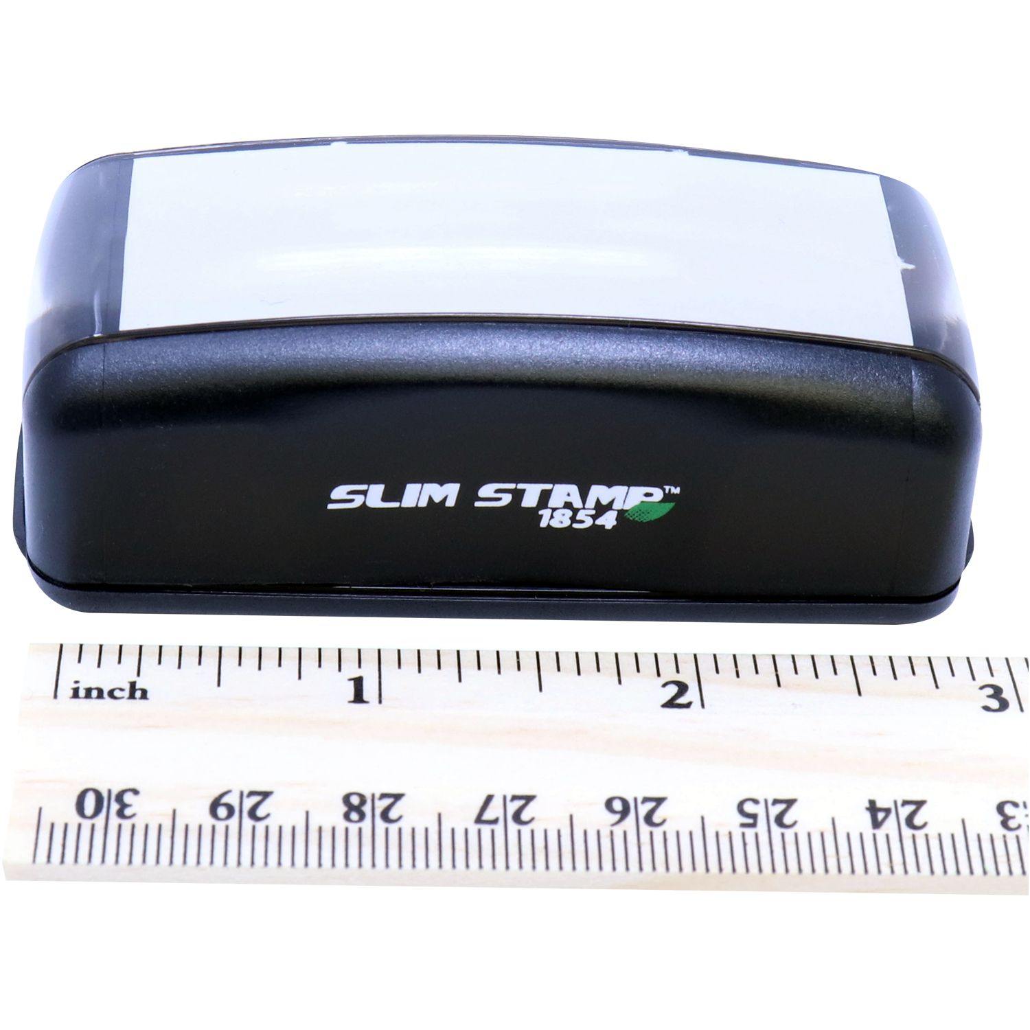 Slim Pre-Inked Superceded Stamp 1854 in black, placed next to a ruler for size reference.