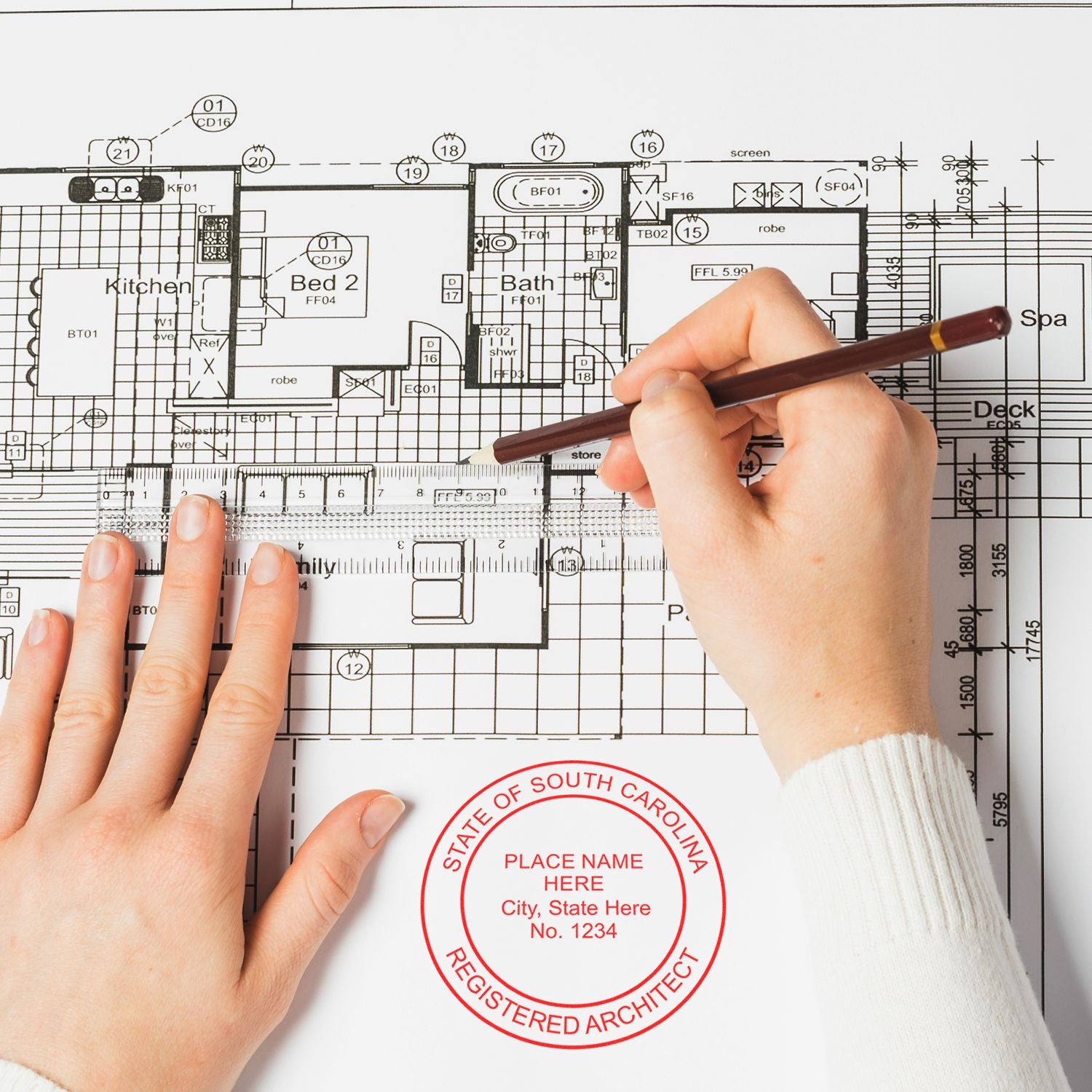 Hands using a pen on a blueprint with a South Carolina Architect Seal Stamp visible, indicating certification and authenticity.