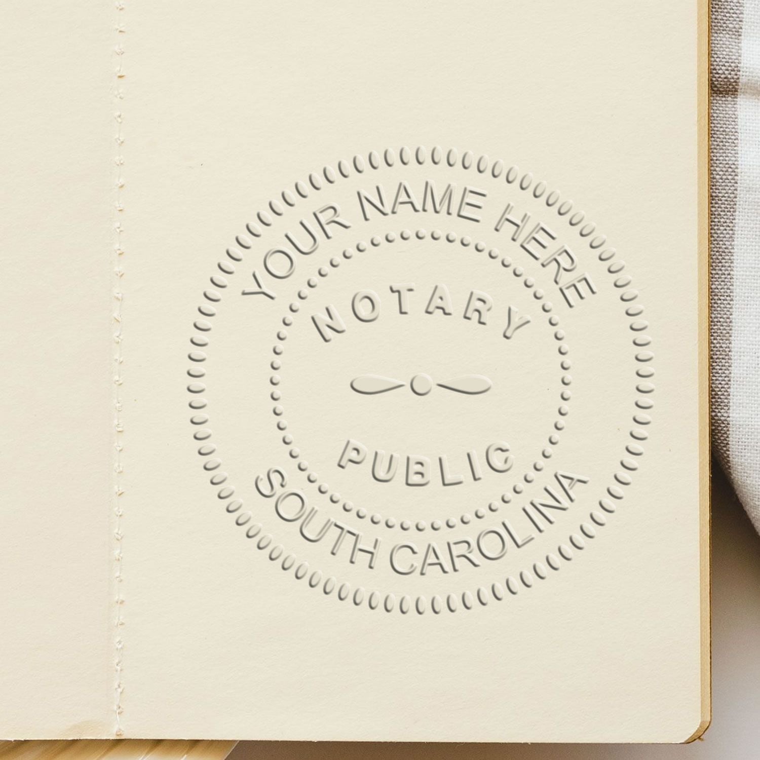 A lifestyle photo showing a stamped image of the South Carolina Handheld Notary Seal Embosser on a piece of paper