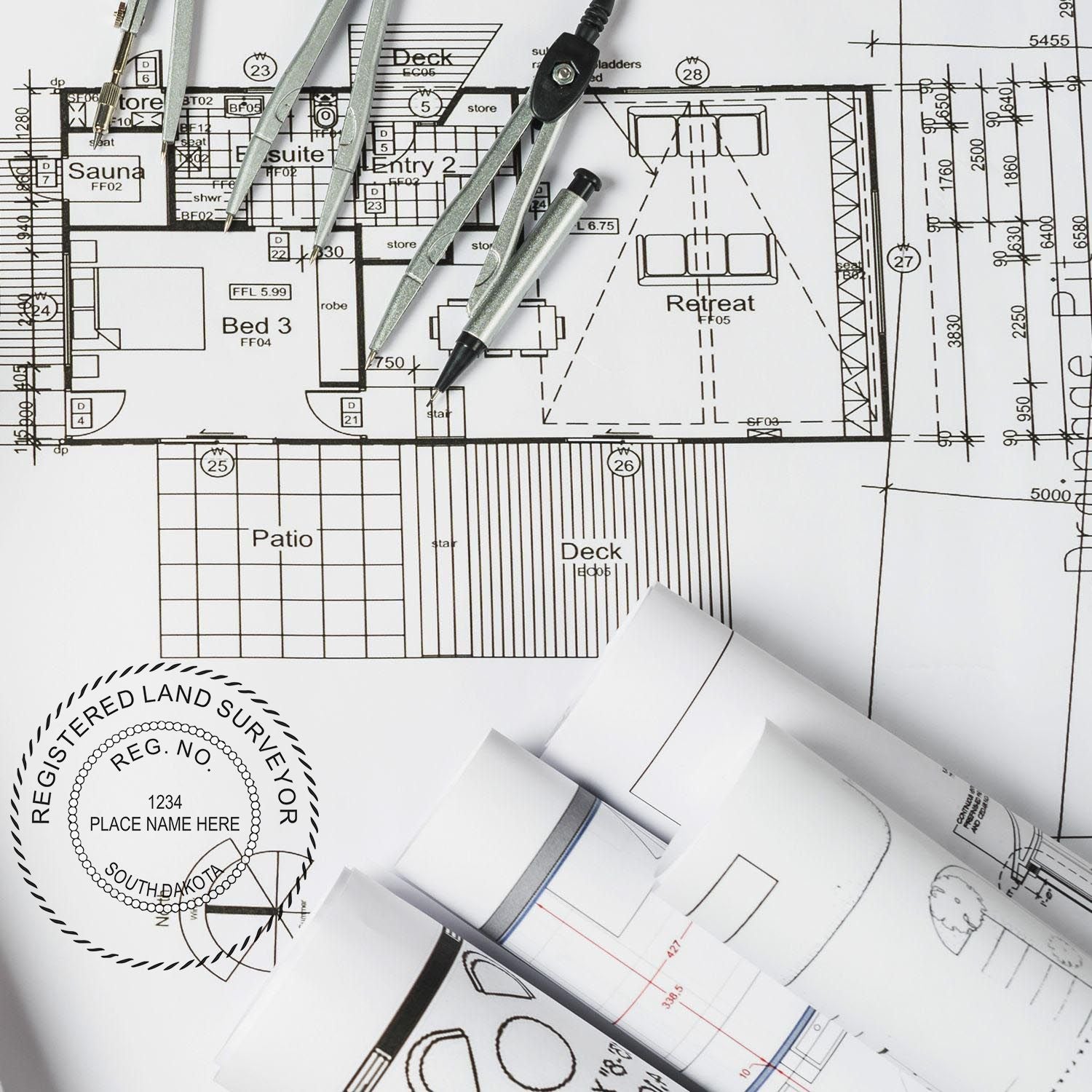 Blueprints and drafting tools with a Digital South Dakota Land Surveyor Stamp, Electronic Seal for South Dakota Land Surveyor in use.