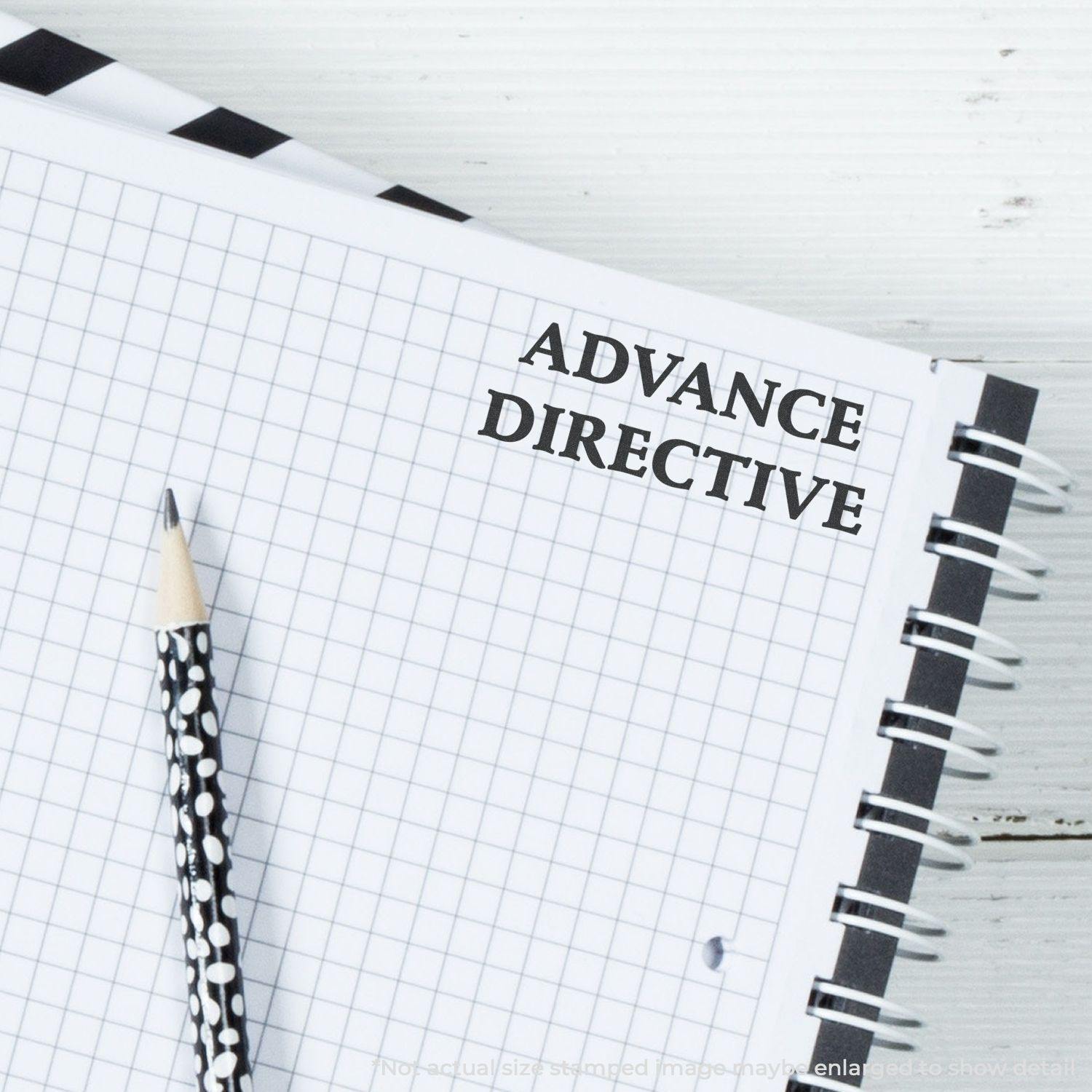 Large Advance Directive Rubber Stamp used on a spiral notebook with a black and white pencil placed on a grid-patterned page.