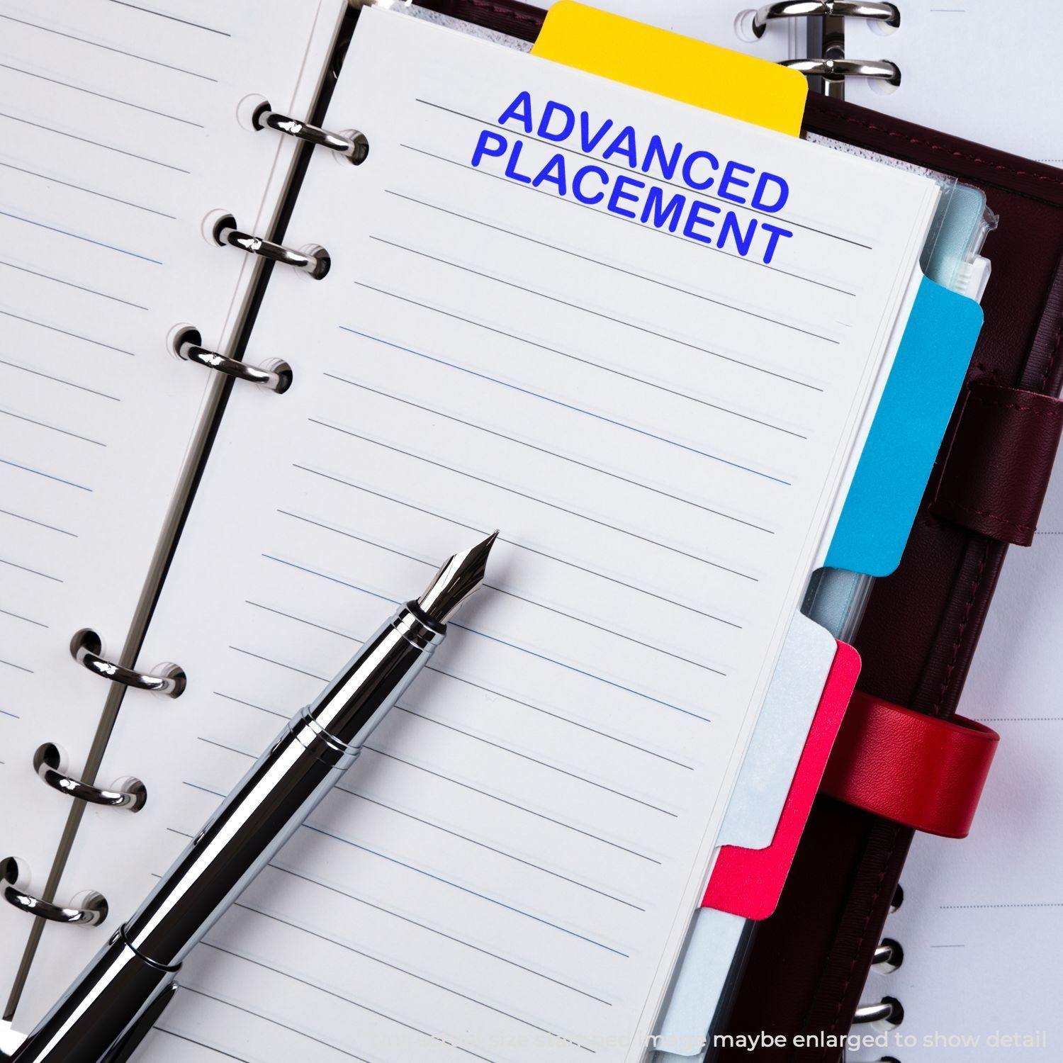 Notebook with 'Advanced Placement' stamped in blue ink, surrounded by colorful tabs and a fountain pen placed on the left.