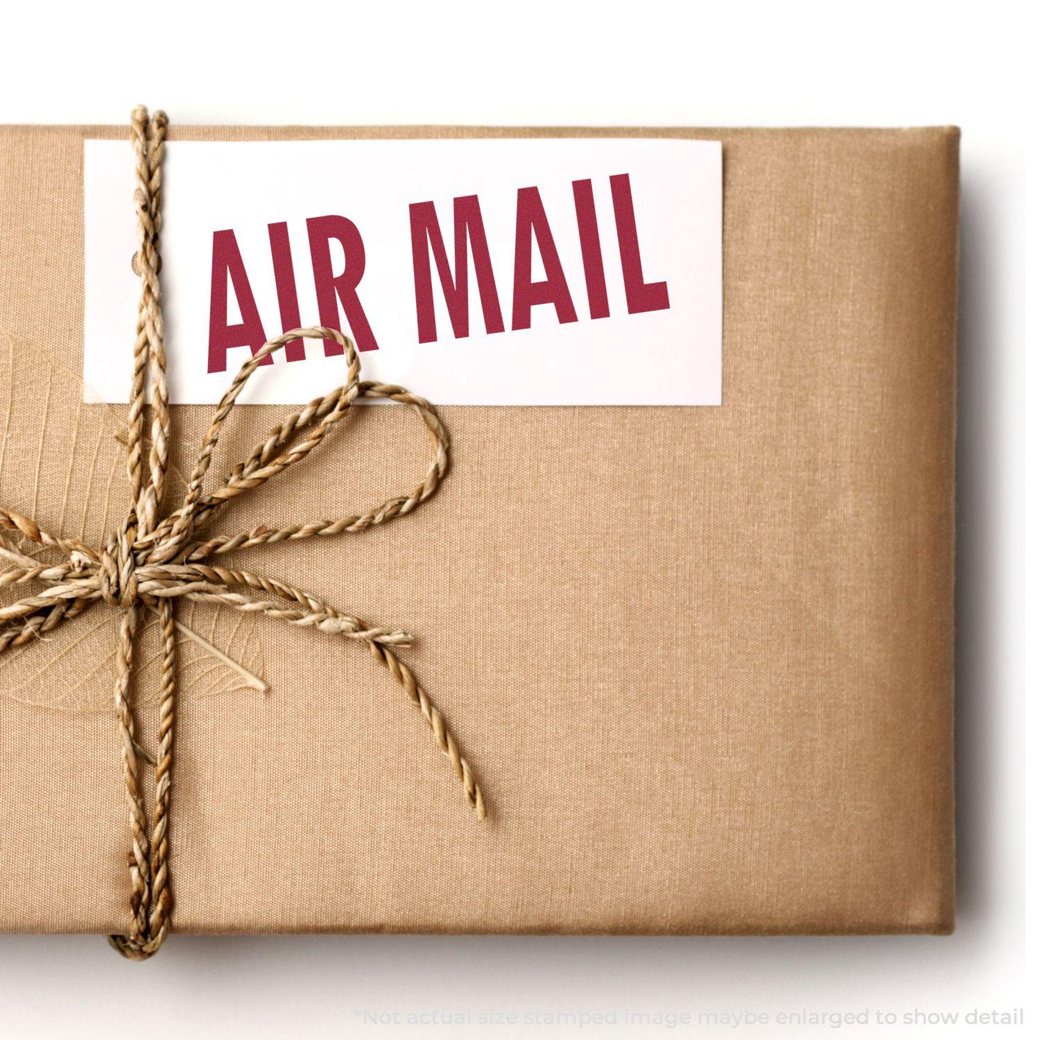 A brown package tied with twine, featuring an Air Mail rubber stamp in red on a white label.