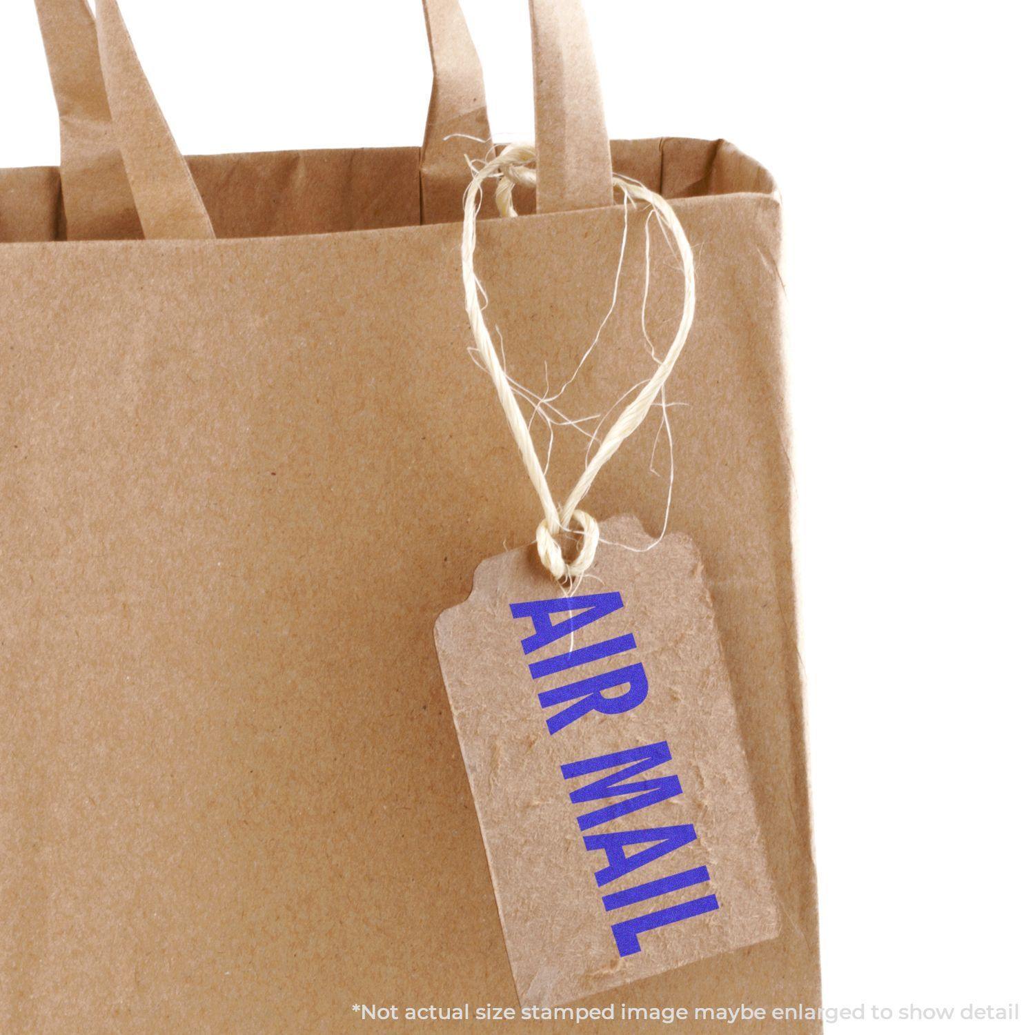 Brown paper bag with a tag attached by twine, featuring a blue Air Mail rubber stamp.