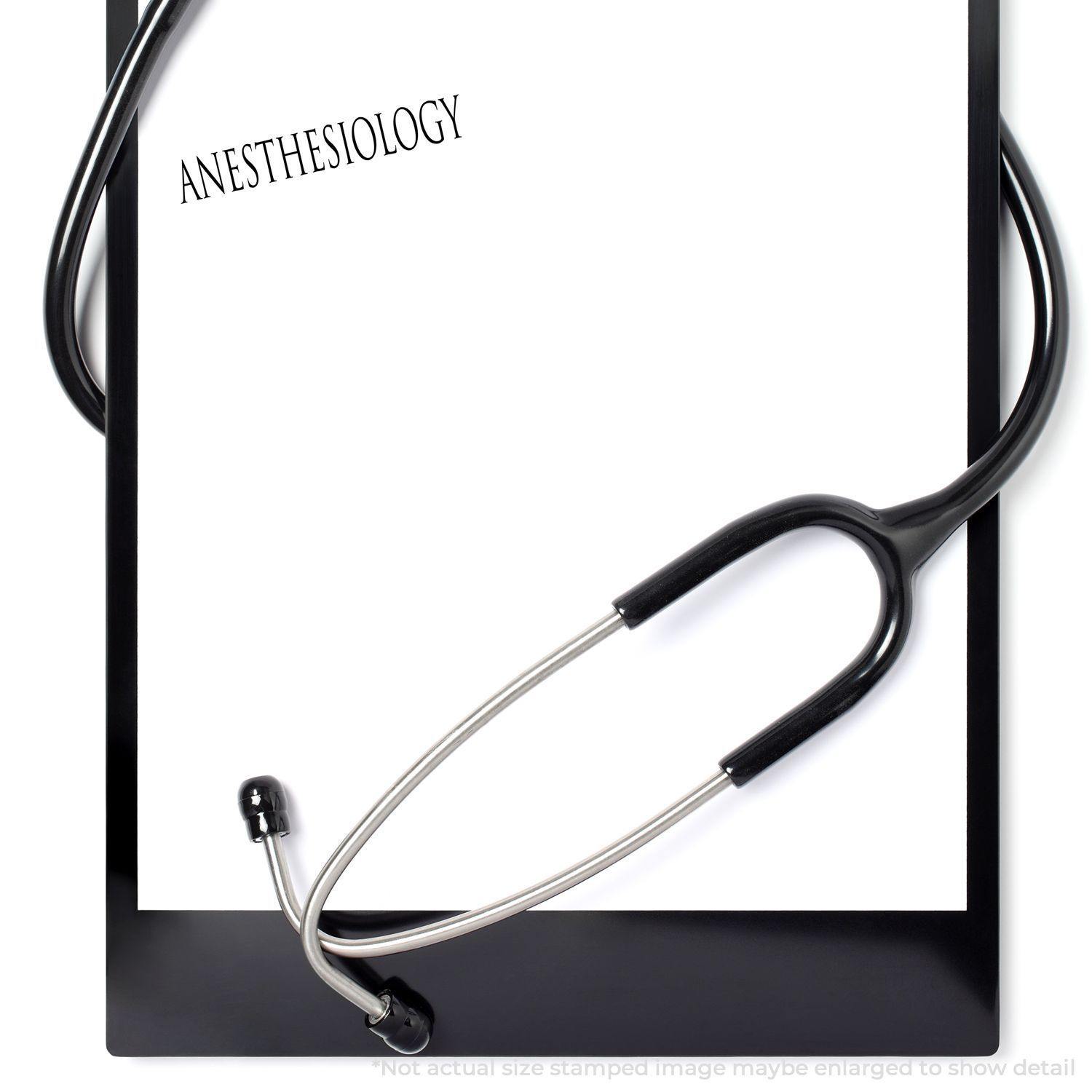 Clipboard with paper stamped Anesthesiology using the Large Self Inking Anesthesiology Stamp, with a stethoscope draped over it.