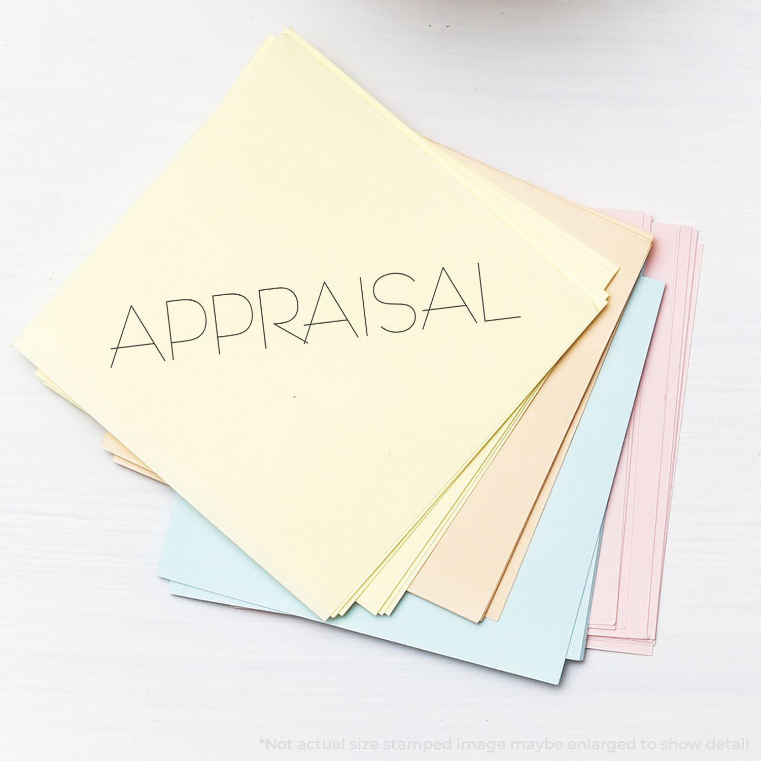 Stack of pastel-colored papers stamped with APPRAISAL using a Slim Pre-Inked Appraisal Stamp on a white surface.