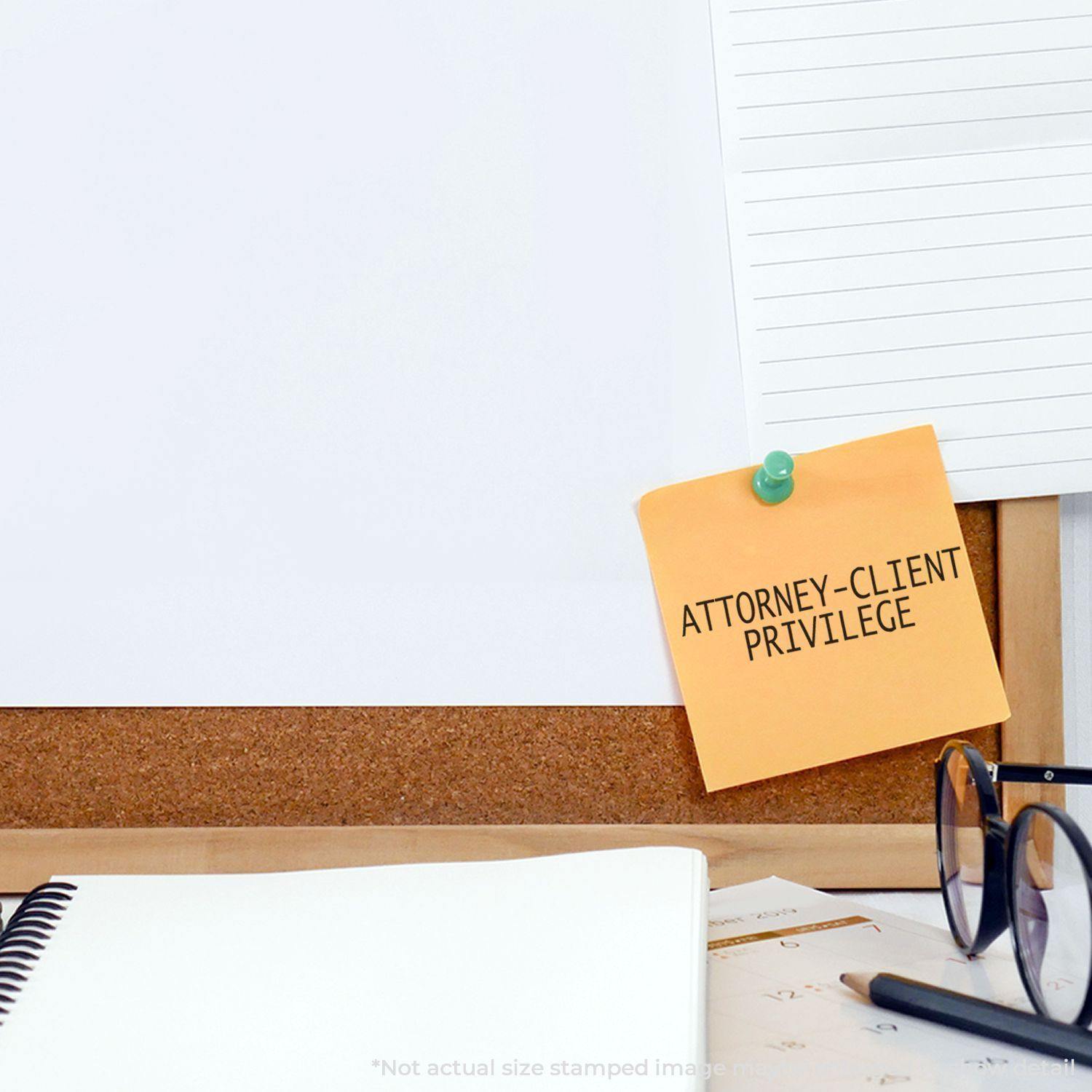 Self Inking Attorney Client Privilege Stamp used on a sticky note pinned to a corkboard, with office supplies and papers nearby.