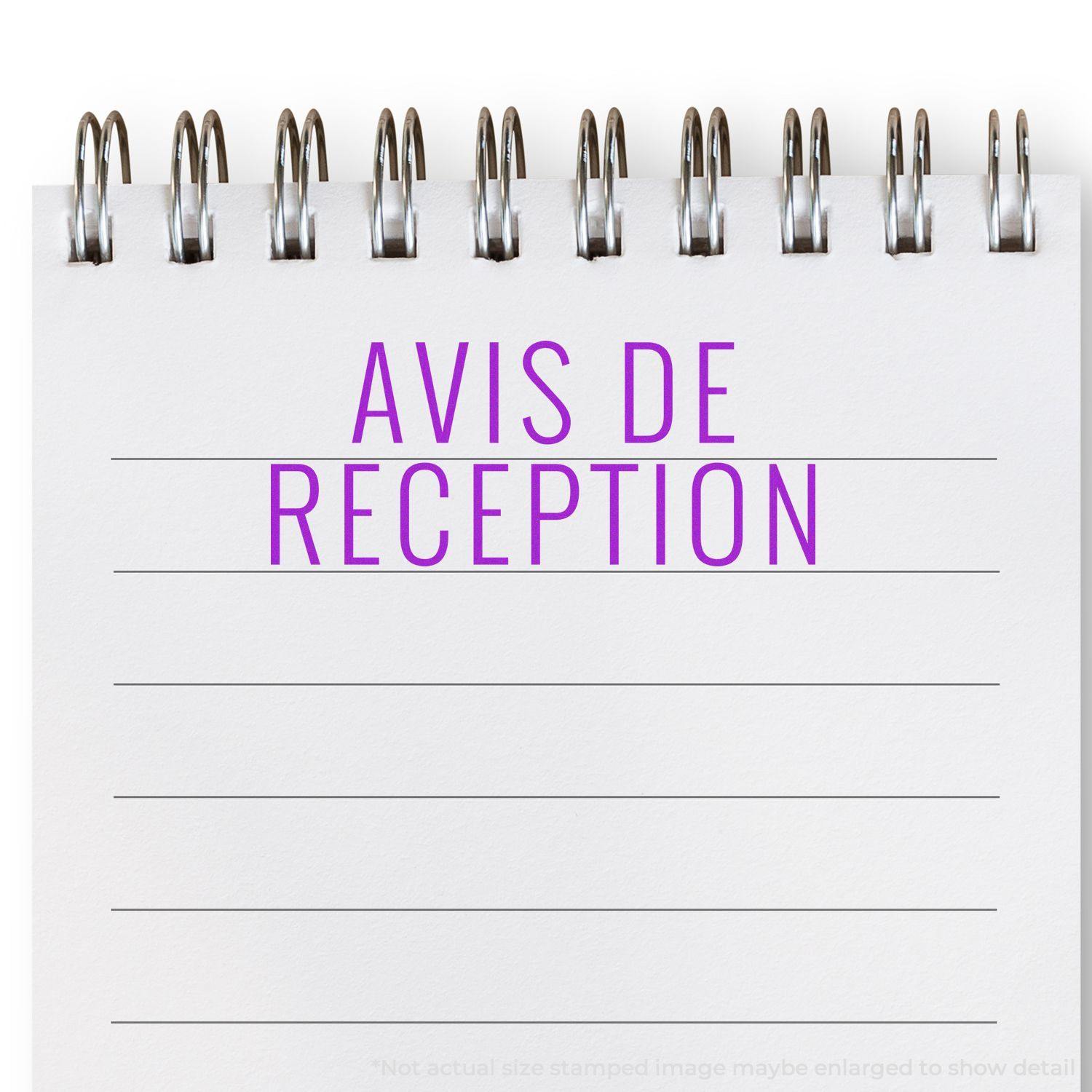 A spiral notebook with Avis De Reception stamped in purple on a blank page, showcasing the Avis De Reception rubber stamp.