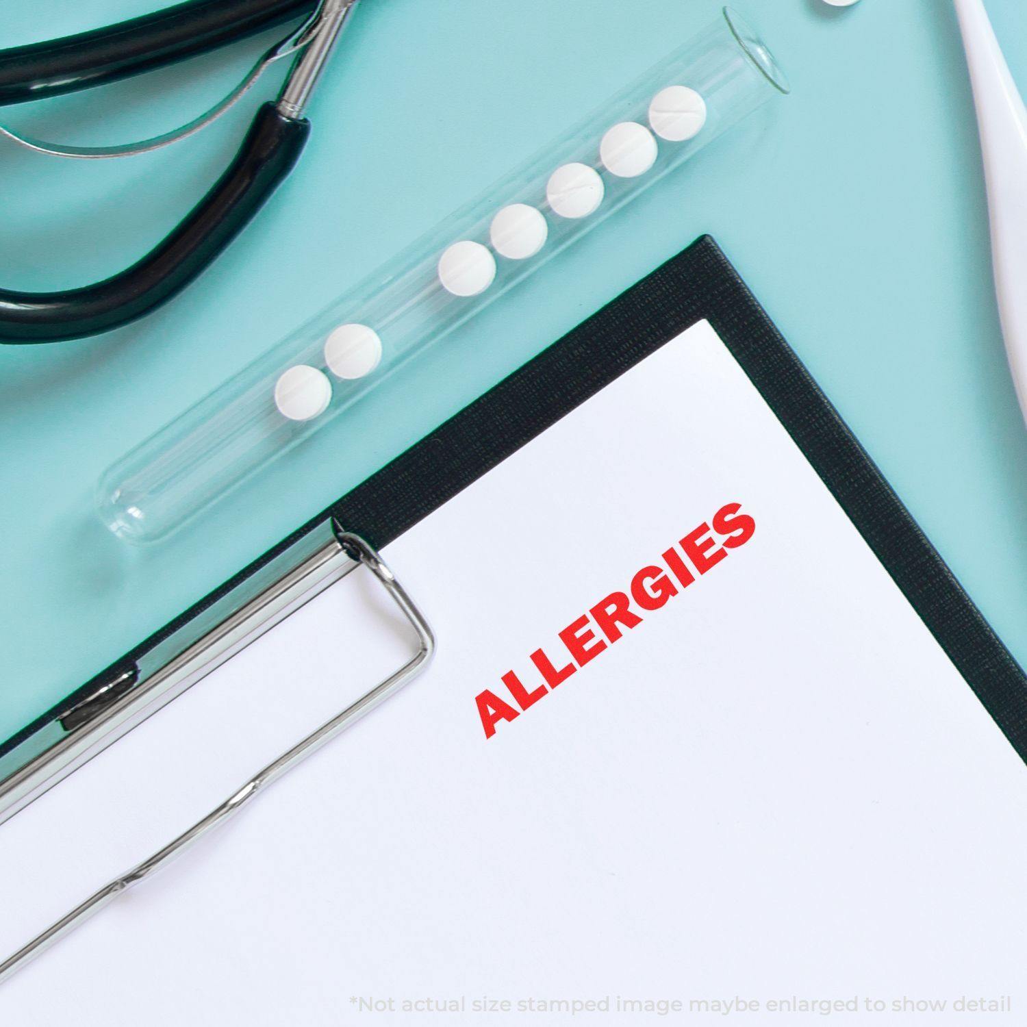 Self Inking Bold Allergies Stamp used on a document, next to a stethoscope and a test tube with pills on a light blue background.