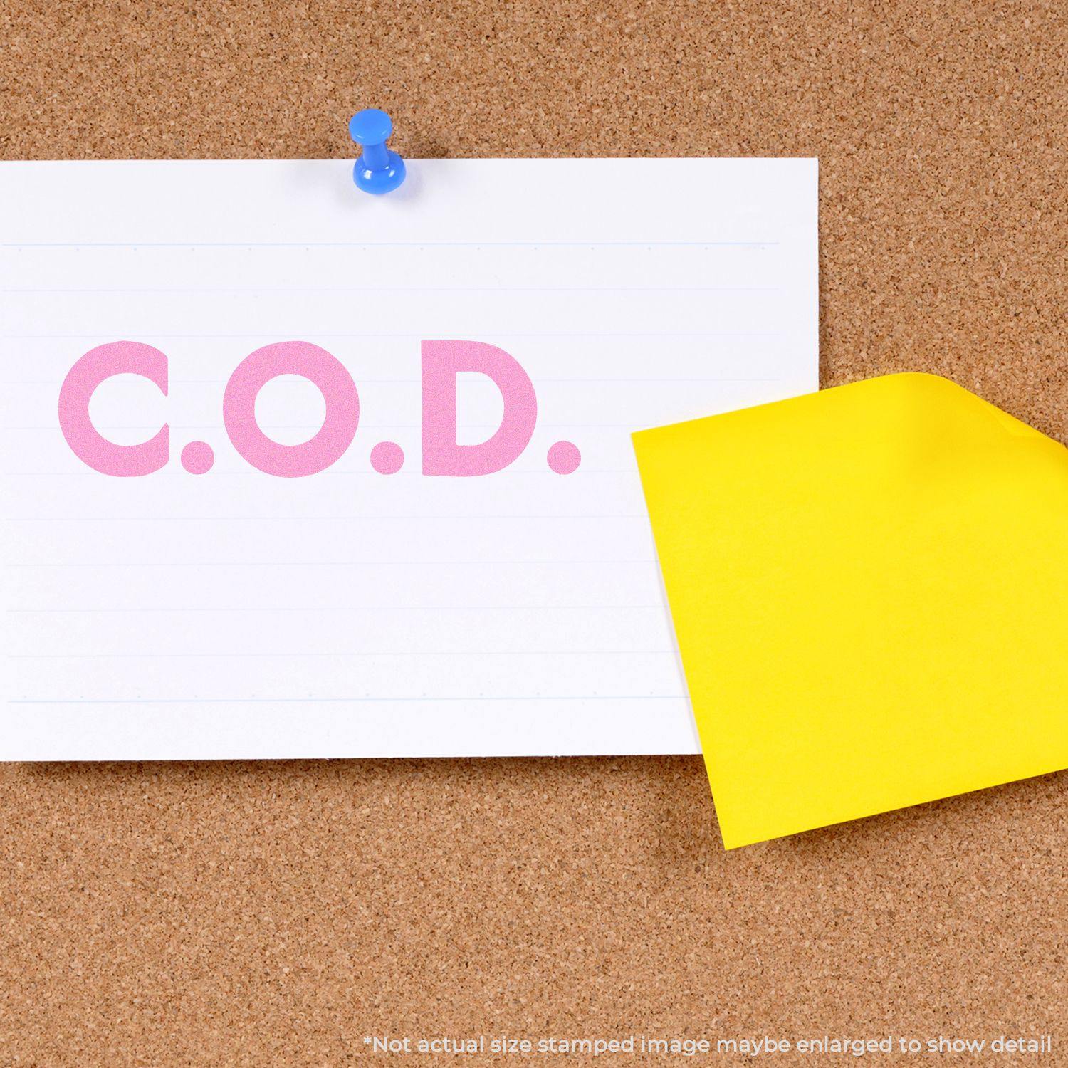 Bold COD rubber stamp on a white paper pinned to a corkboard, with a yellow sticky note partially covering the paper.