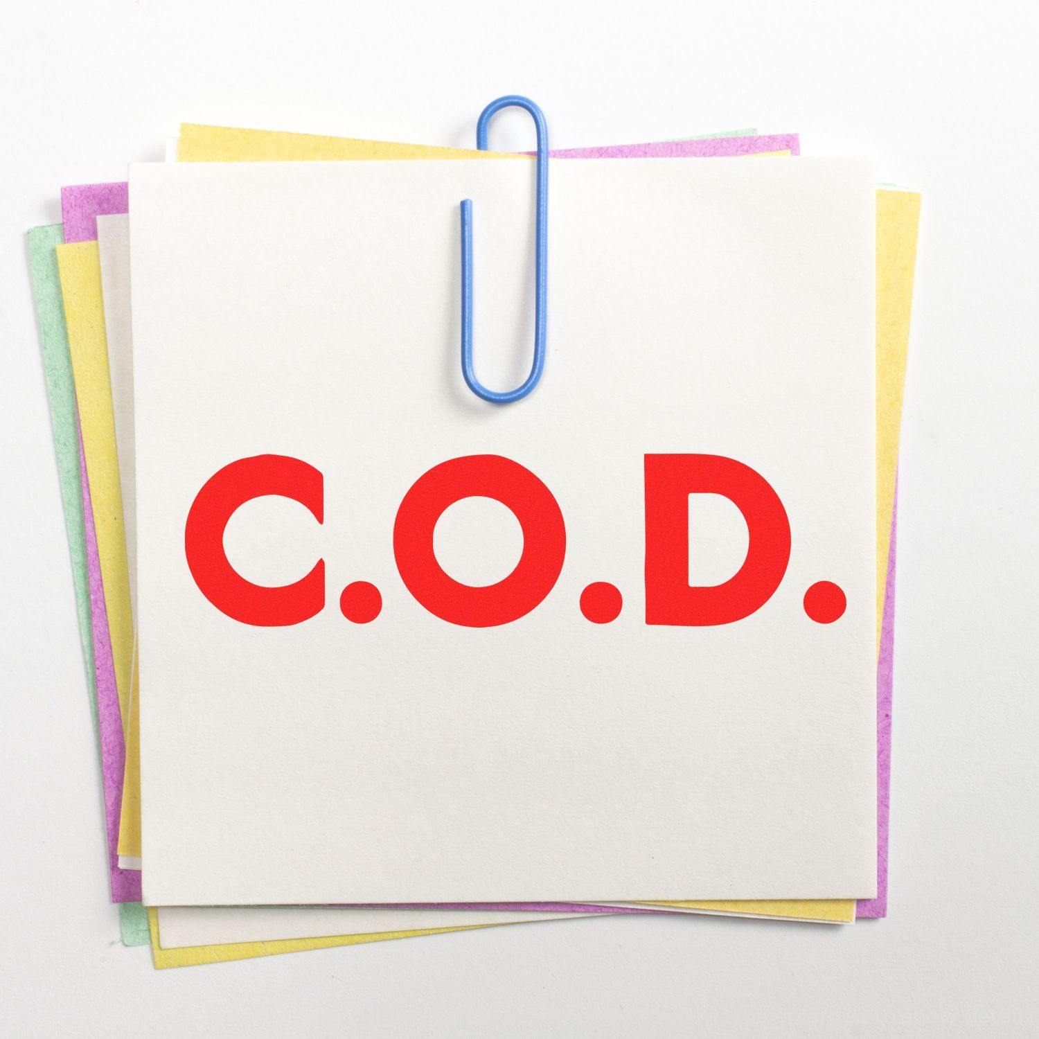 Large Self Inking Bold C.O.D. Stamp in red ink on a white paper clipped to colorful sheets, displayed on a white background.