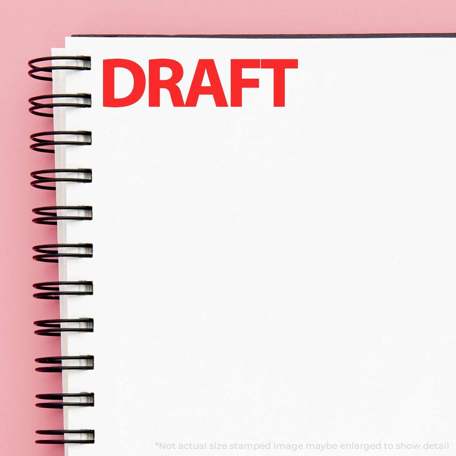 Notebook with 'DRAFT' stamped in bold red ink on the top left corner using a Slim Pre-Inked Bold Draft Stamp.