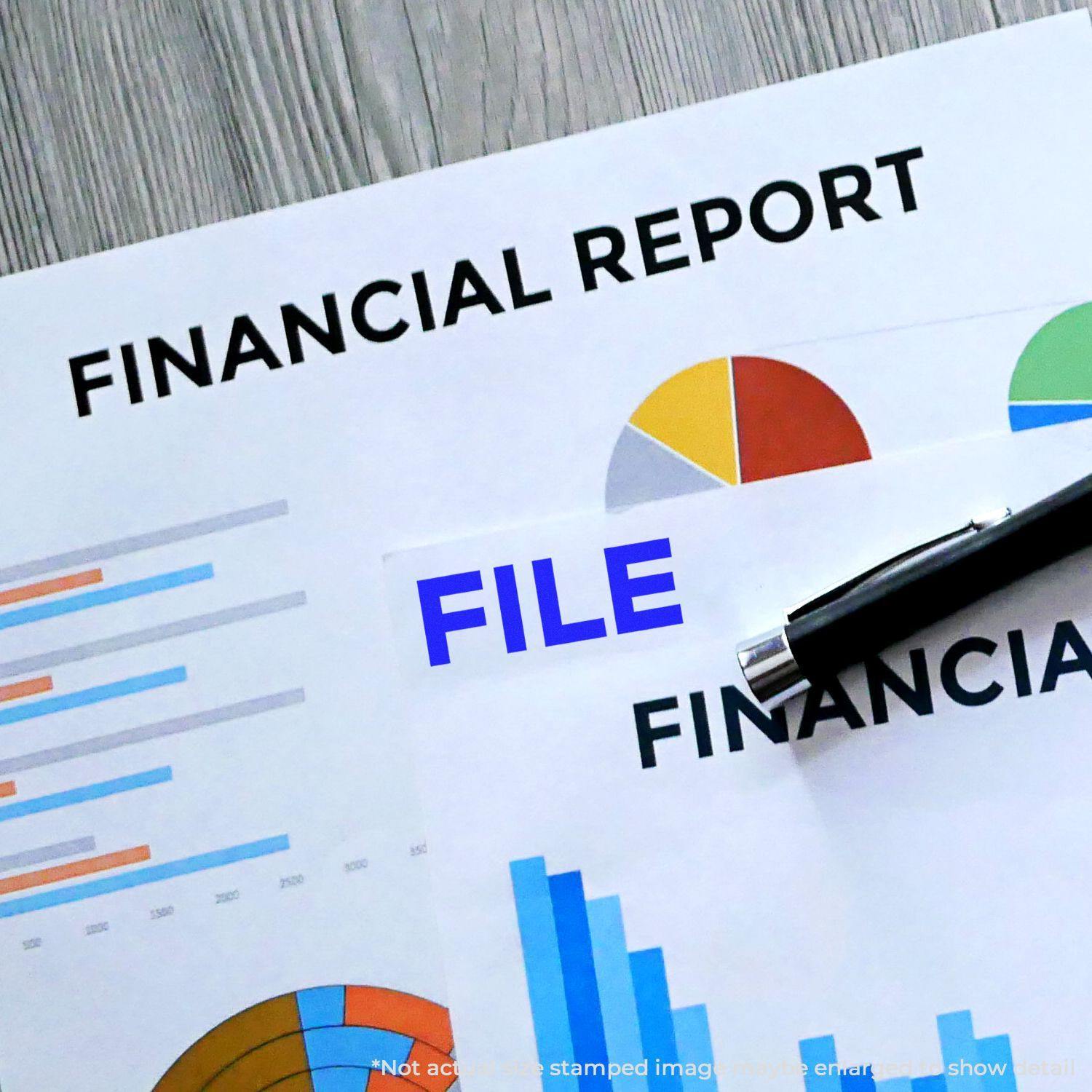 Financial documents with charts and graphs stamped with FILE using the Large Bold File Rubber Stamp, placed on a wooden surface.