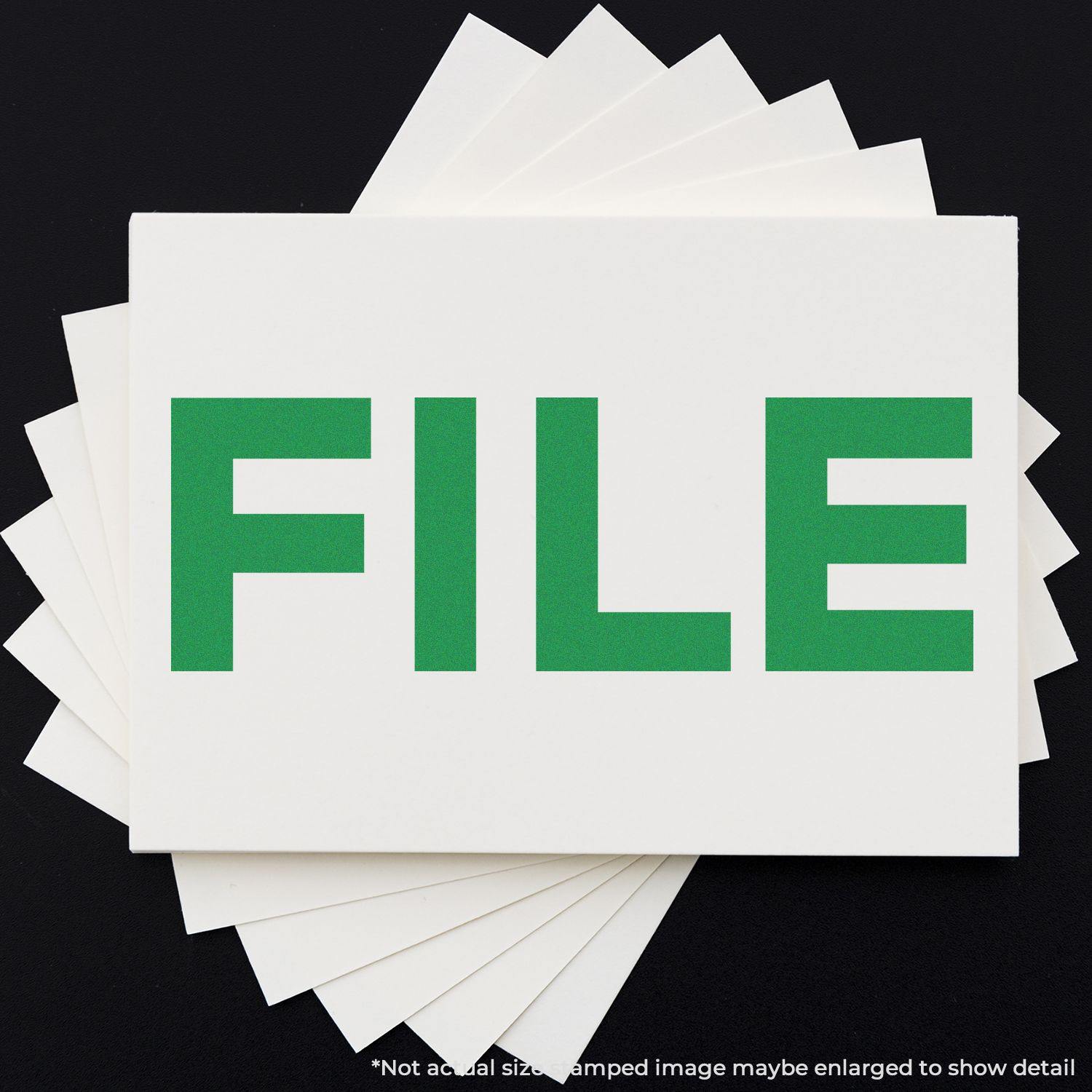 Large Self Inking Bold File Stamp in green ink on white paper, with multiple sheets fanned out underneath.