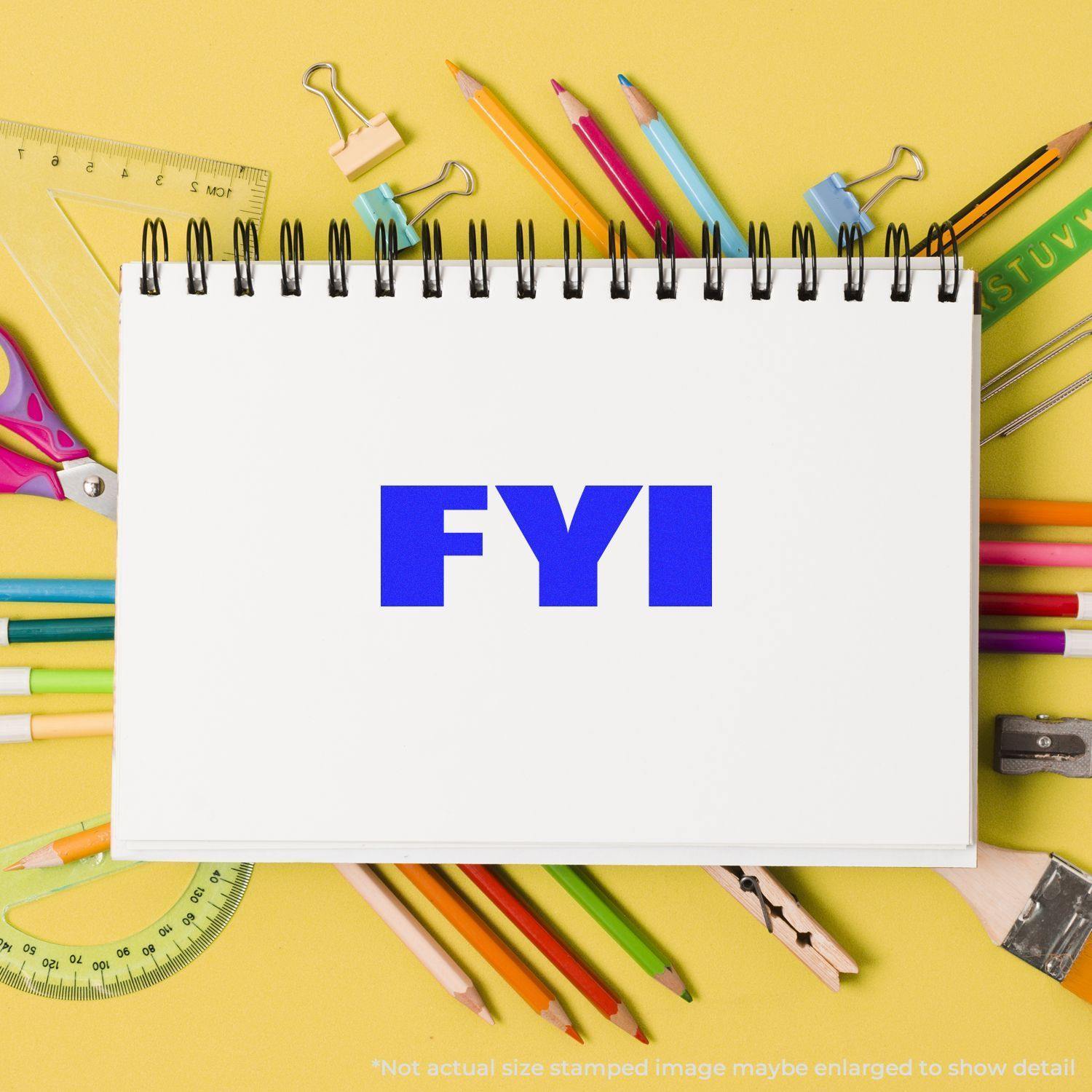 Large Self Inking Bold FYI Stamp in blue ink on a white notepad, surrounded by colorful stationery on a yellow background.