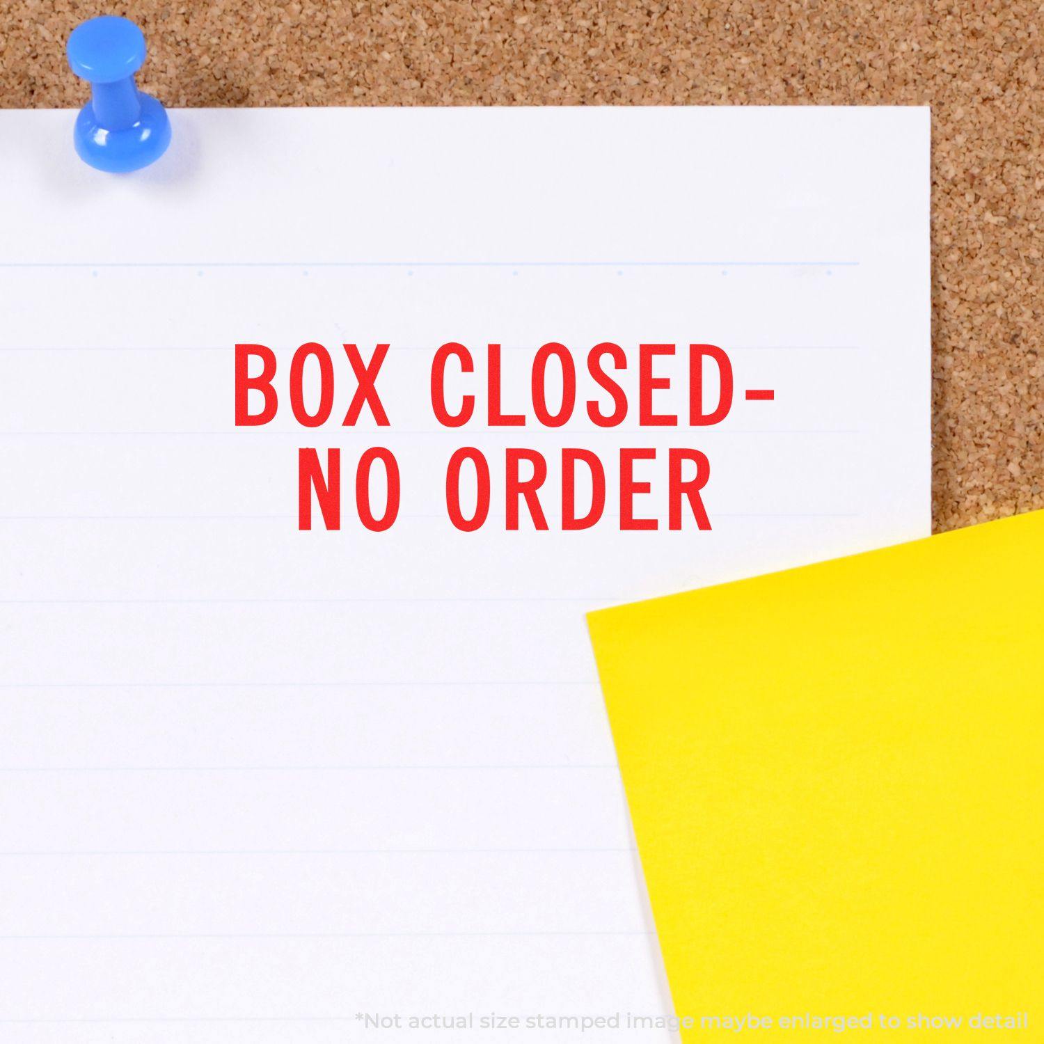 Box Closed No Order rubber stamp impression on a white paper pinned to a corkboard with a blue pushpin and a yellow paper.