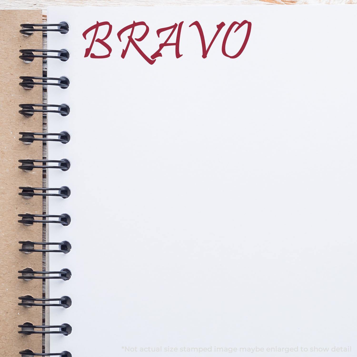 Large Pre-Inked Bravo Stamp imprint on a white notebook page with a spiral binding, showing the word BRAVO in red ink.