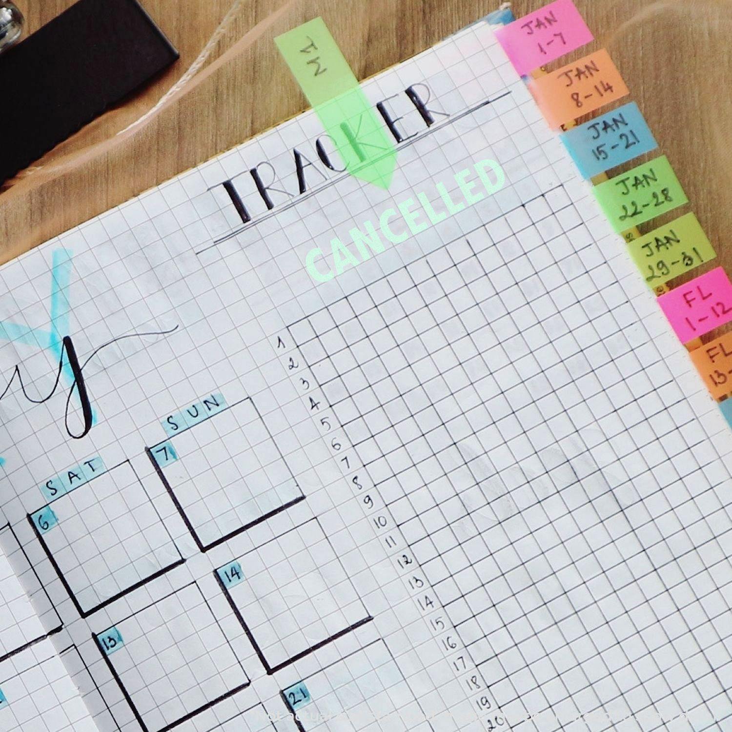 Planner with a grid layout and colorful tabs, featuring a 'Cancelled' rubber stamp prominently on the tracker section.