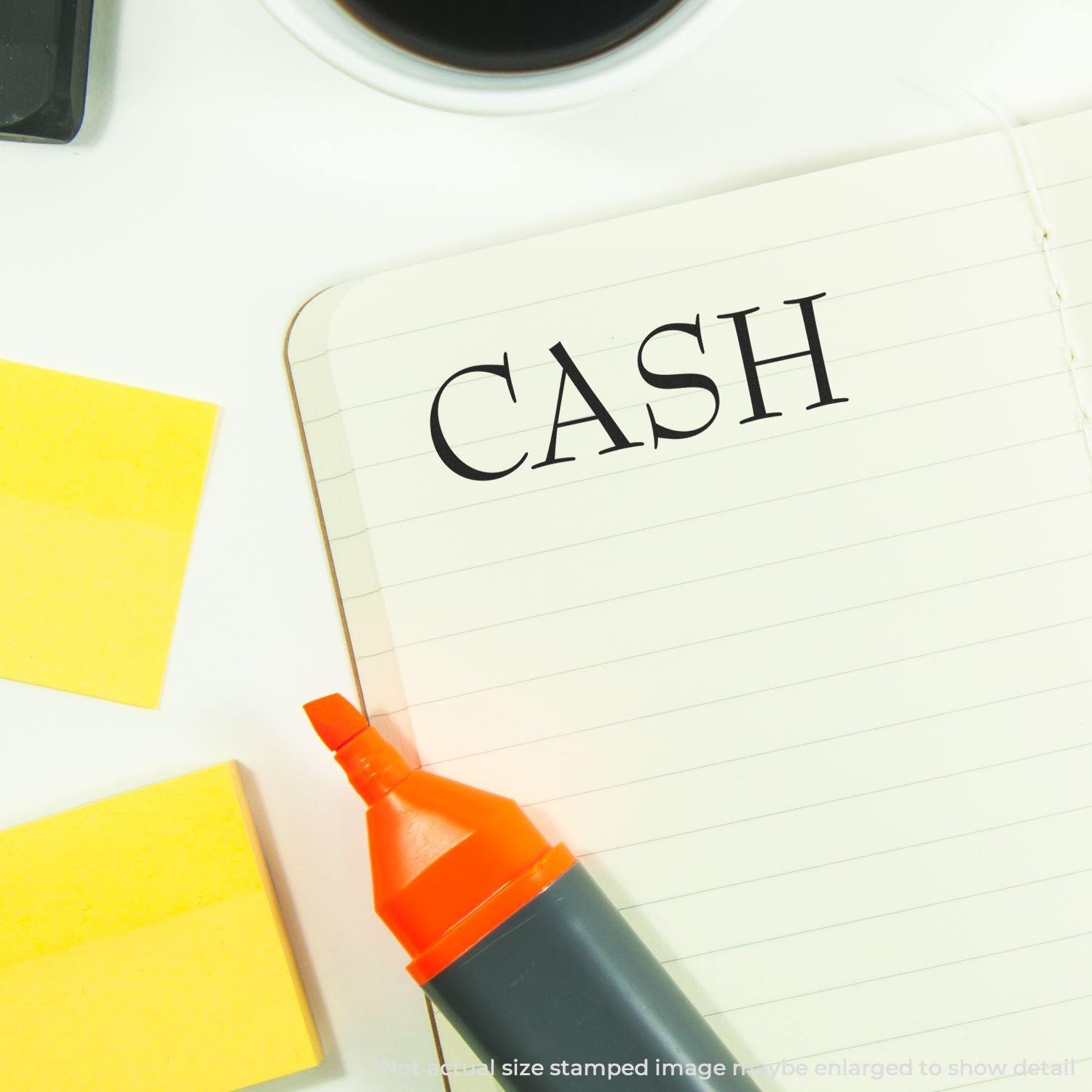 Notebook with 'CASH' stamped in bold letters, next to a highlighter, sticky notes, and a coffee cup. Focus: Cash Rubber Stamp.