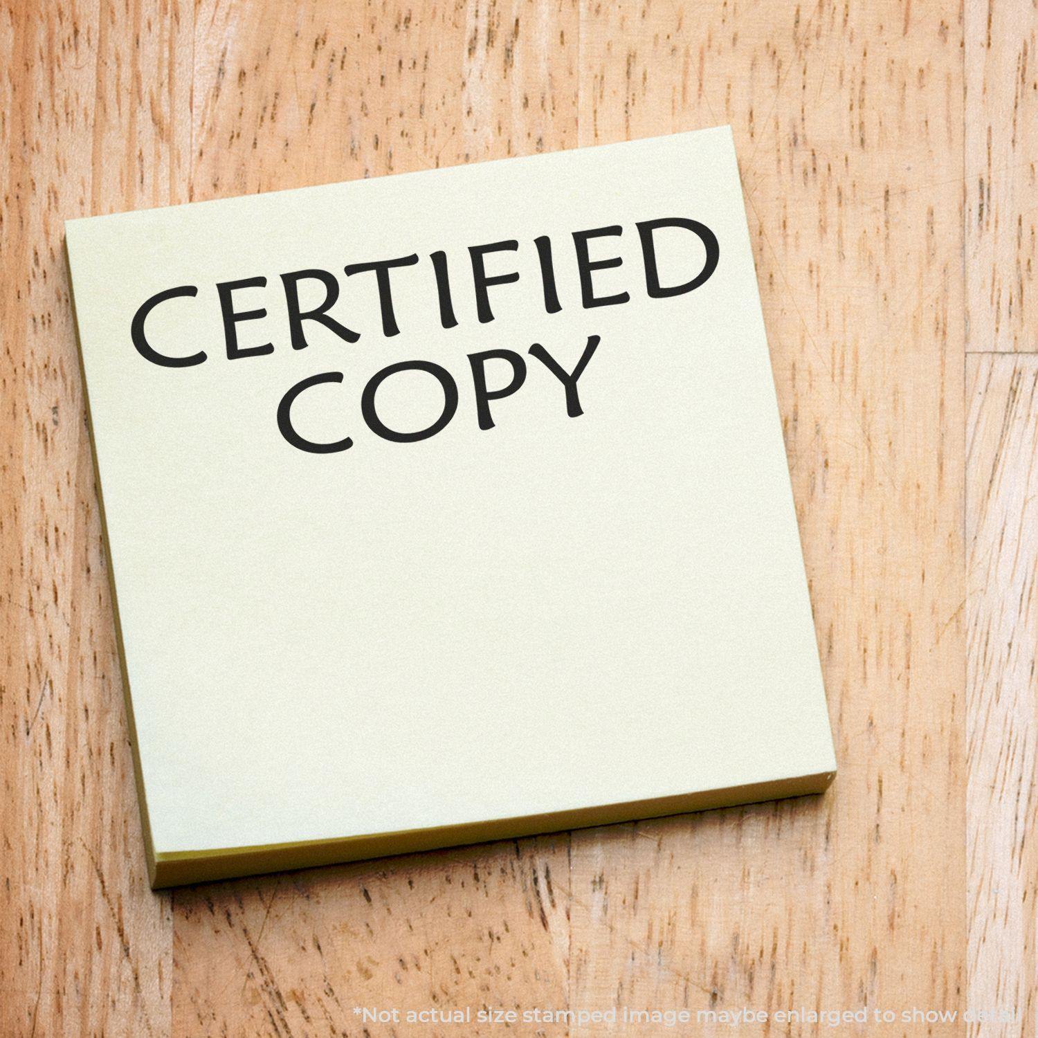 Large Self Inking Certified Copy Stamp imprint on a yellow sticky note placed on a wooden surface.