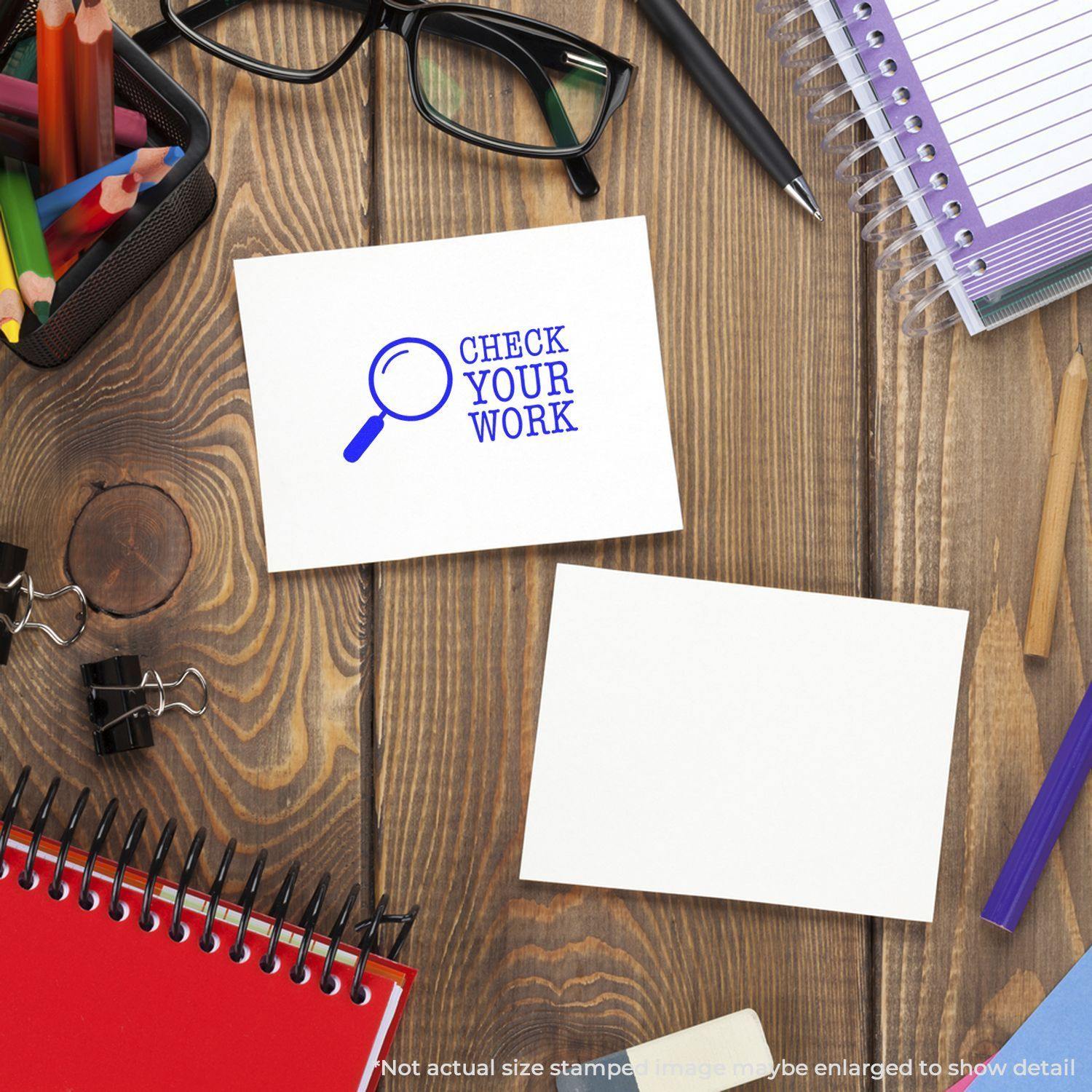 A desk with office supplies, including notebooks, pens, glasses, and two cards. One card is stamped with CHECK YOUR WORK using the Large Self Inking Check Your Work Stamp.